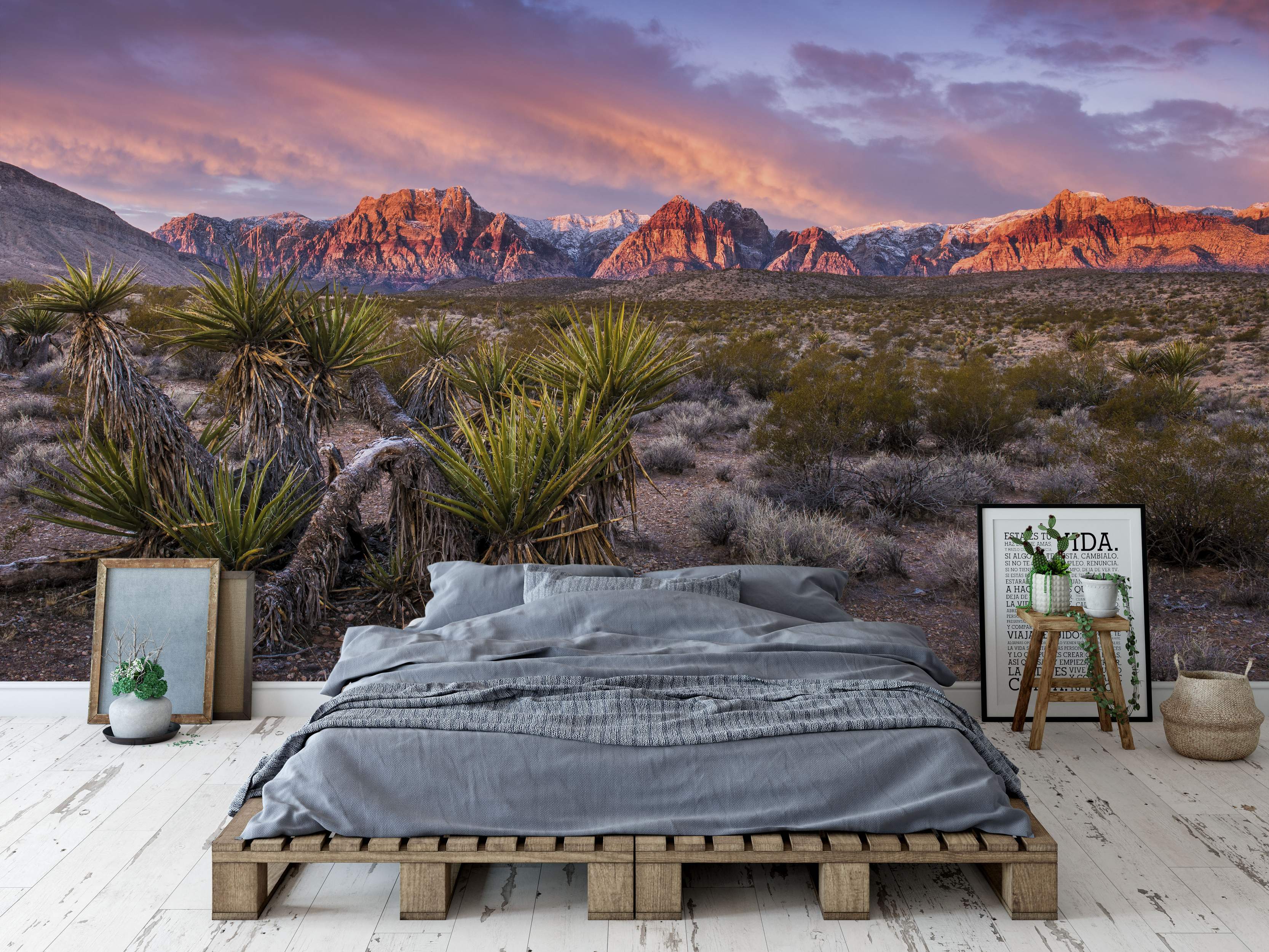 Desert landscape mural featuring snow-capped mountains lit pink and orange by sunset under a purple sky, with yuccas foreground.