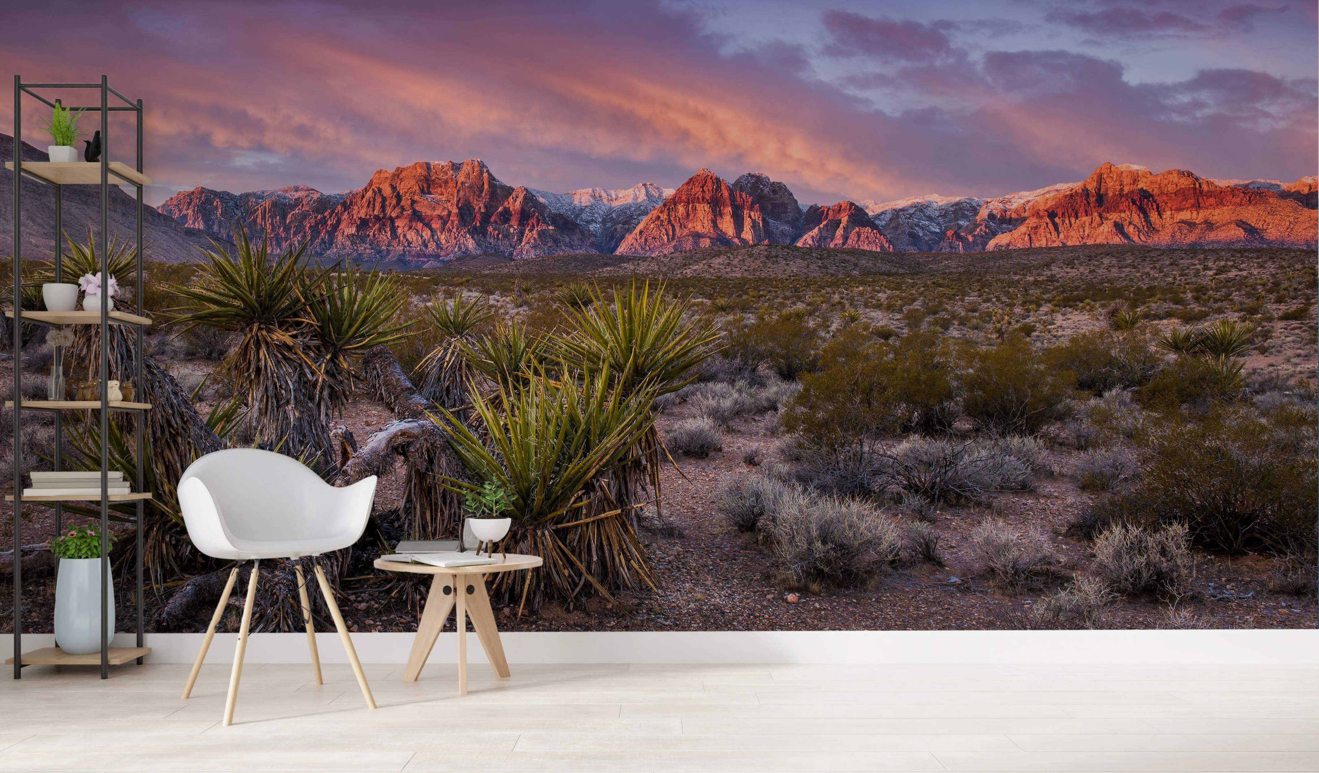 Desert landscape mural showing red mountains under a purple sunset sky, with yucca plants and scrub in the foreground.