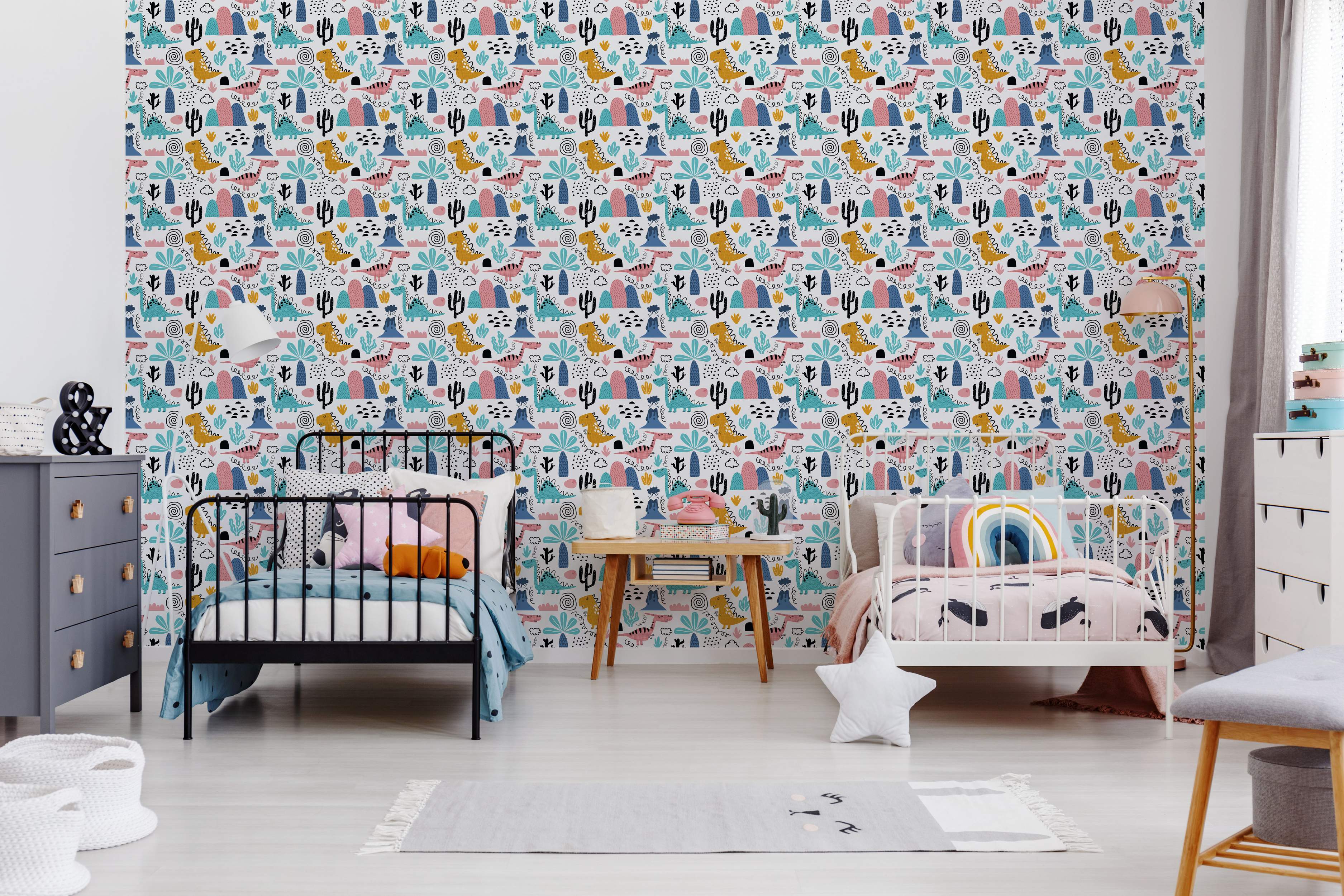 Playful cartoon dinosaur wallpaper featuring blue, yellow, and pink dinosaurs, cacti, and volcanoes on a white background.