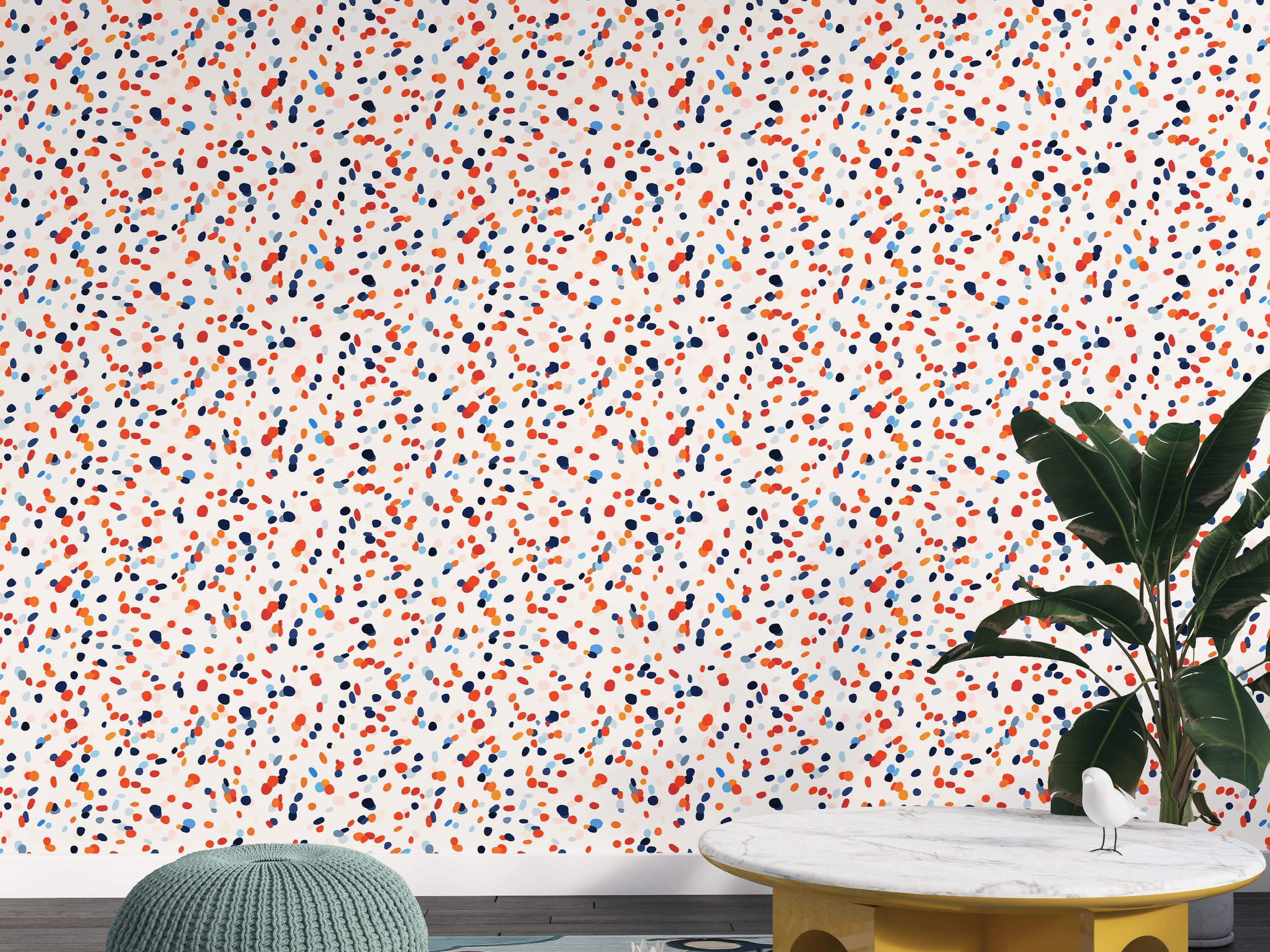 Wallpaper featuring scattered dots in red, orange, dark blue, and light blue on an off-white field.