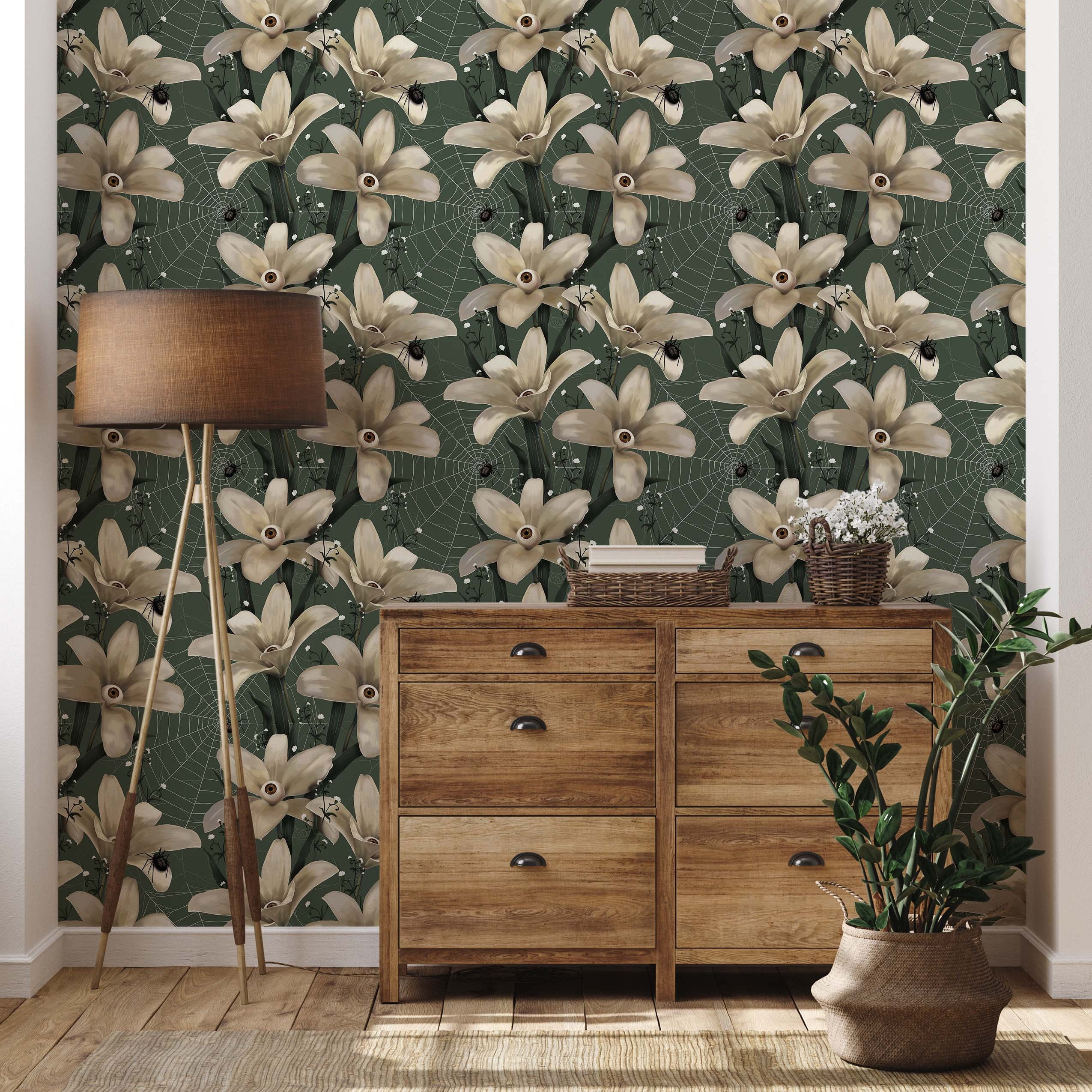 Gothic floral wallpaper with cream-colored flowers with eyeballs, black spiders, and webs on a dark green background.