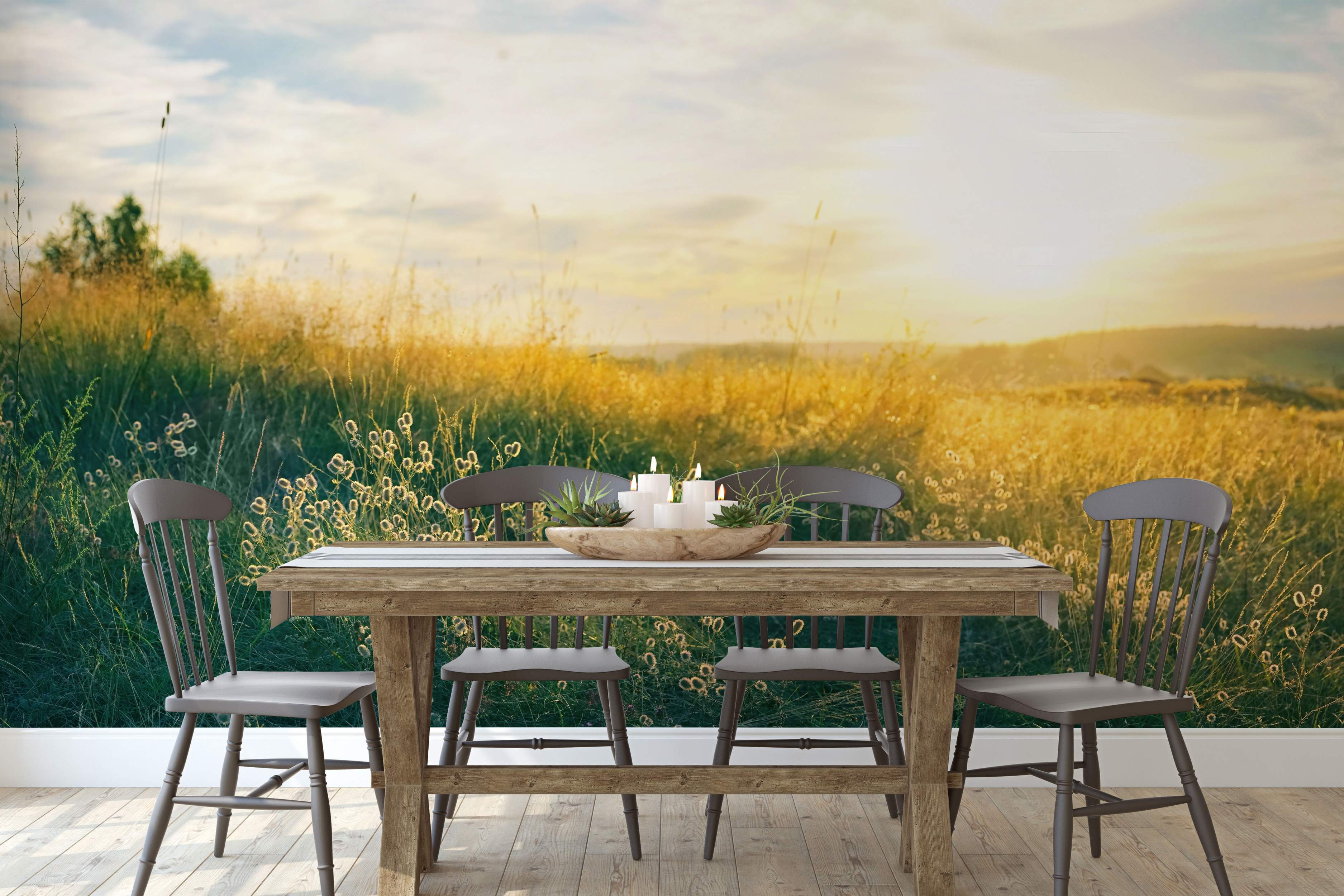 Photographic mural capturing a sunlit grassy field at sunset, featuring warm yellow and green tones under a soft sky.