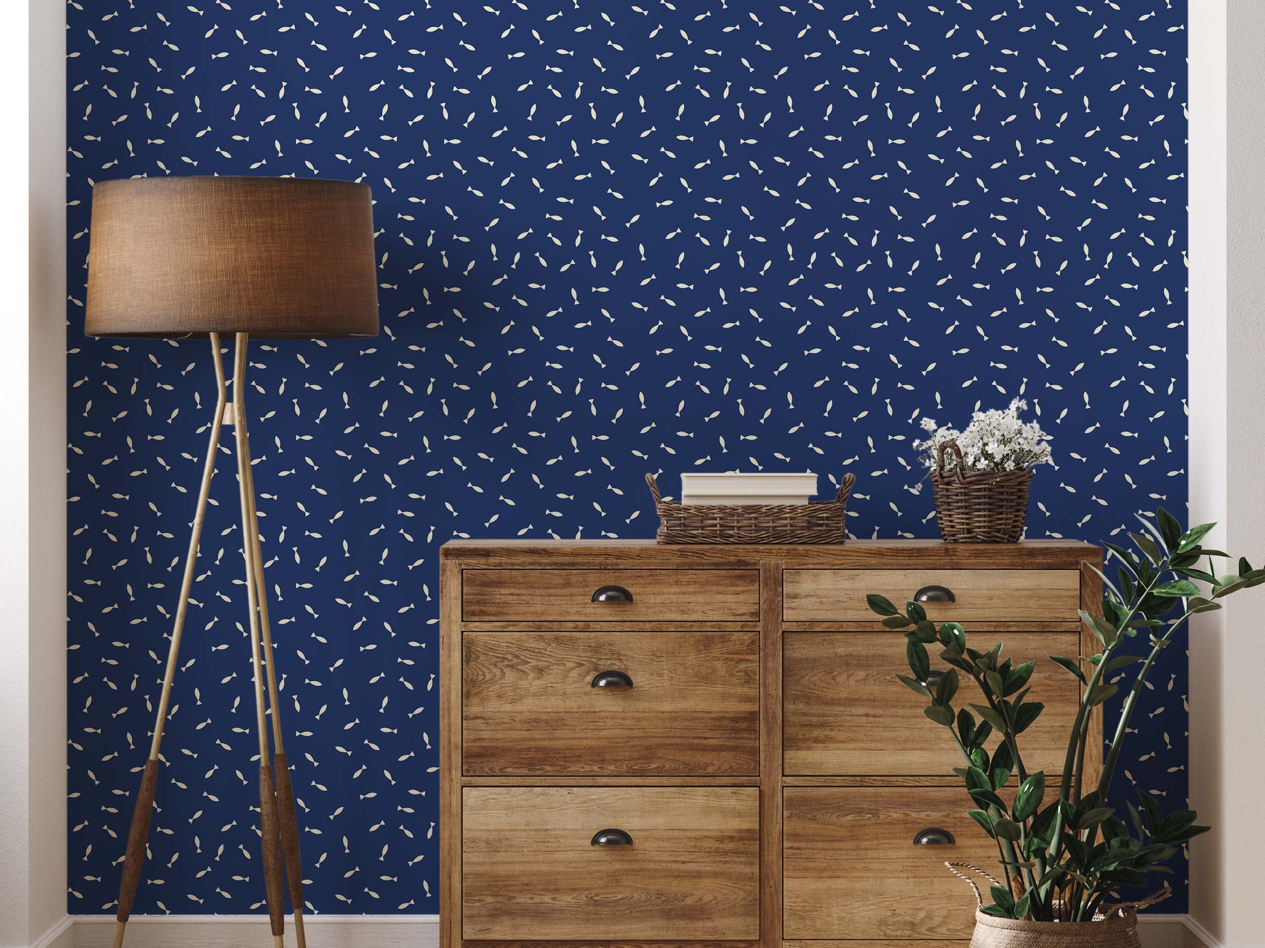 A whimsical wallpaper featuring a scattered pattern of small, cream-colored fish on a dark blue background.