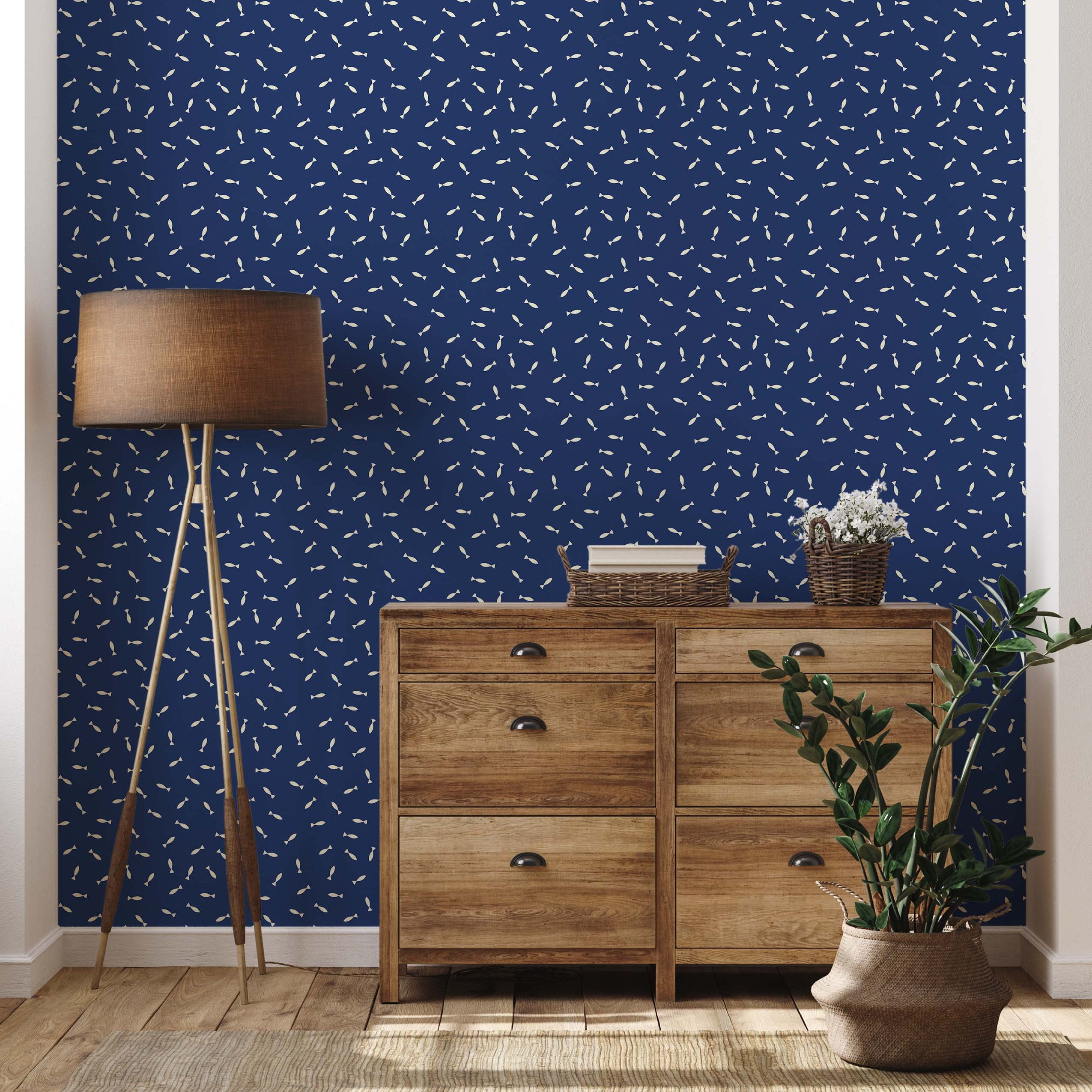 A whimsical wallpaper featuring a scattered pattern of small, cream-colored fish on a dark blue background.