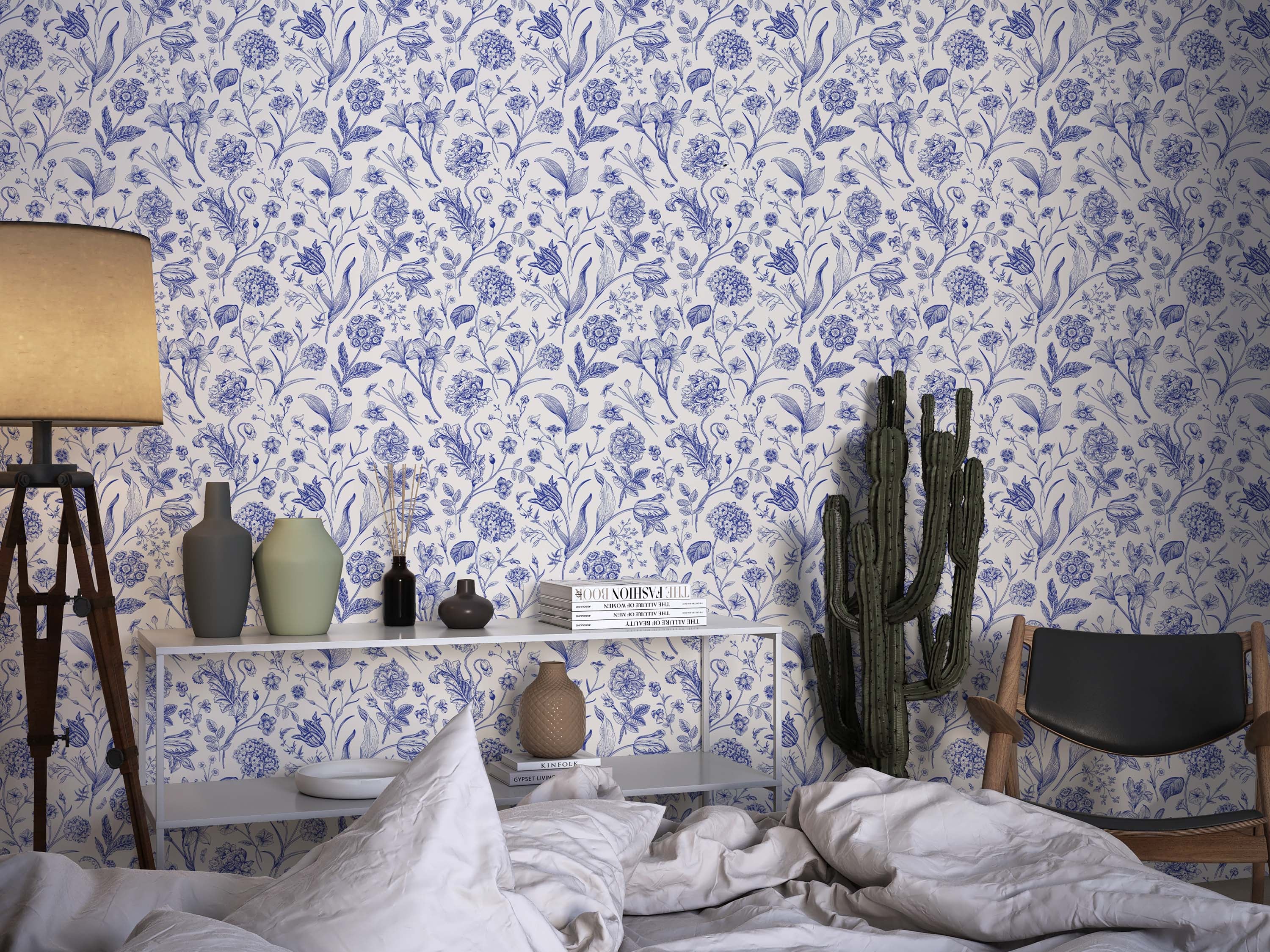 A botanical wallpaper with detailed, blue line drawings of various flowers and leaves scattered across an off-white background.