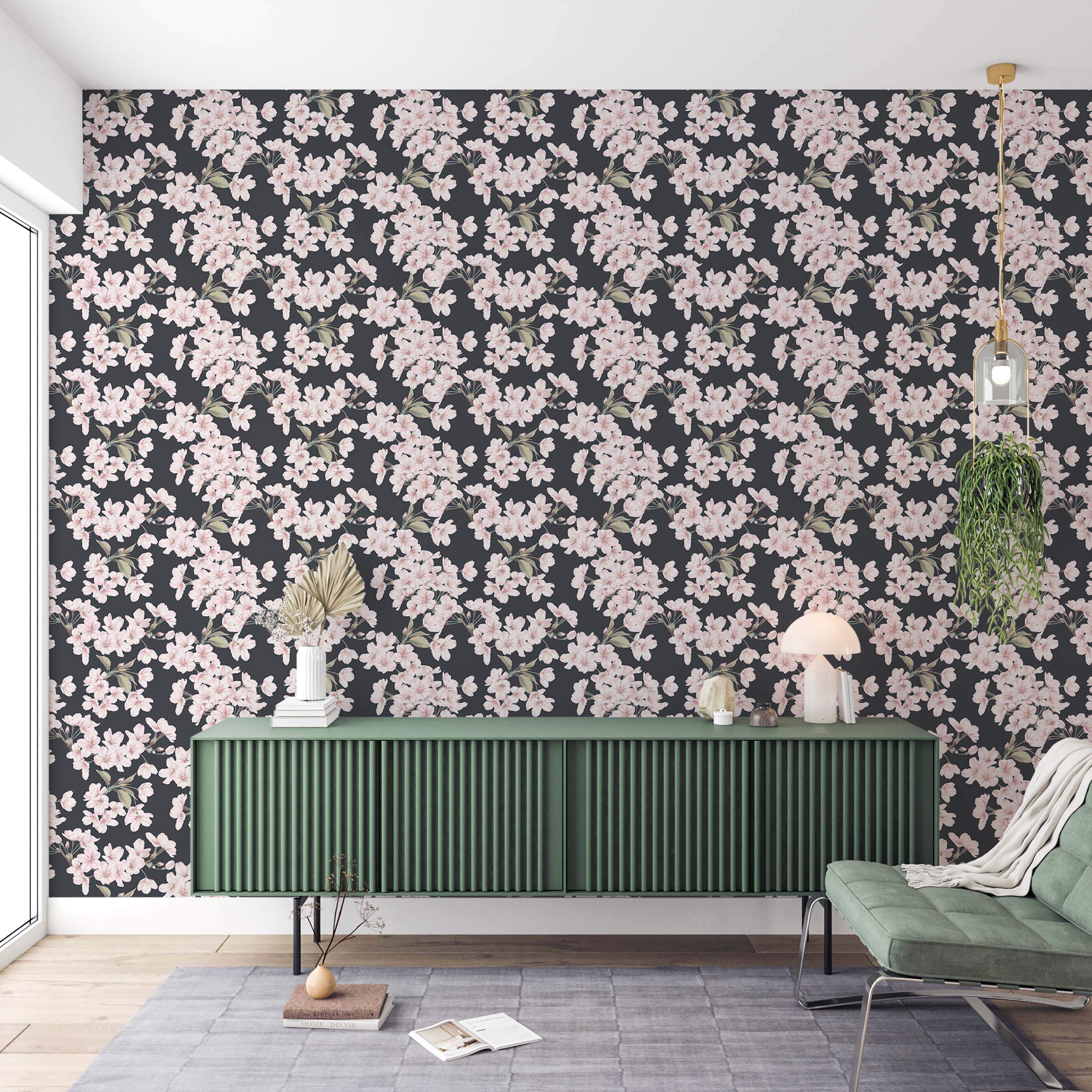 Wallpaper featuring clusters of light pink cherry blossoms with green leaves scattered across a dark gray background.