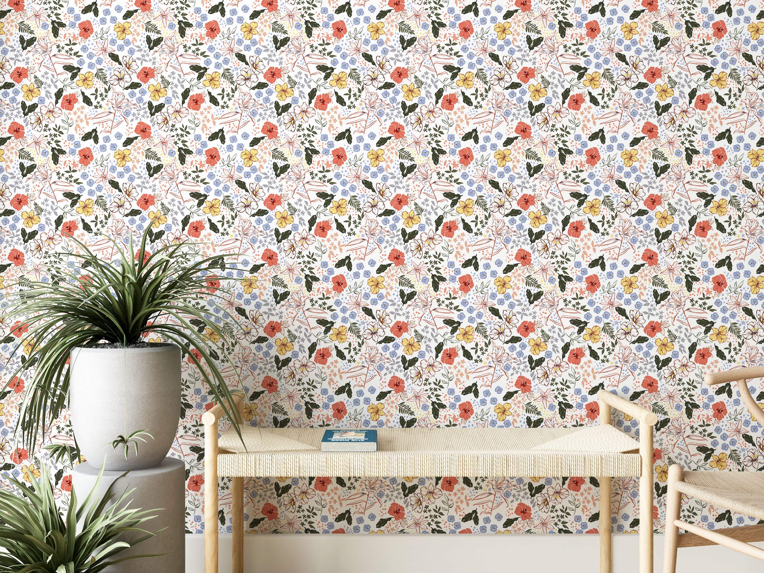 Wallpaper with a dense floral pattern featuring coral, yellow, and outlined flowers, small blue blooms, and green leaves on white.
