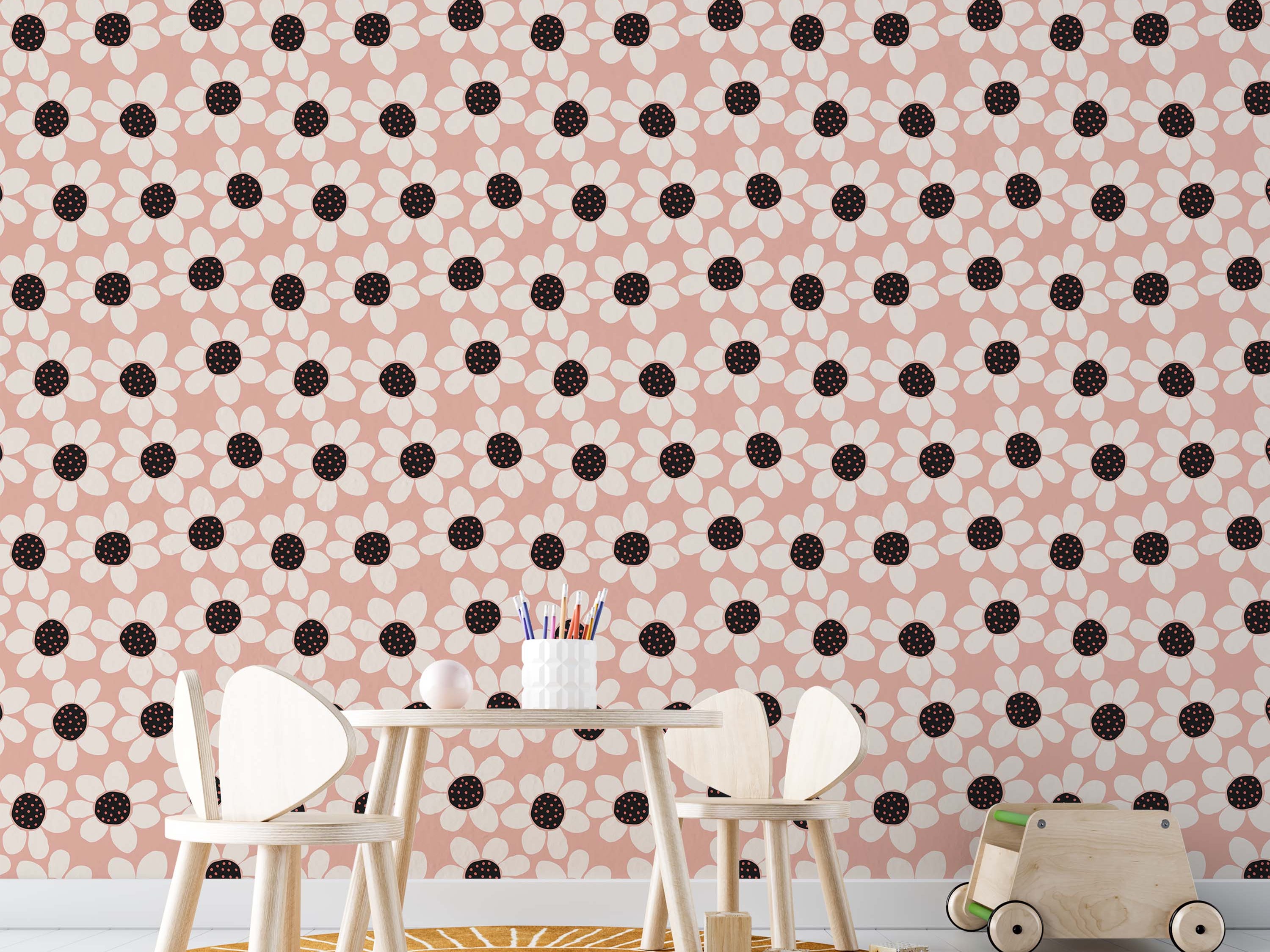 Wallpaper with a repeating floral design: cream daisies with black, pink-dotted centers on a dusty pink ground.