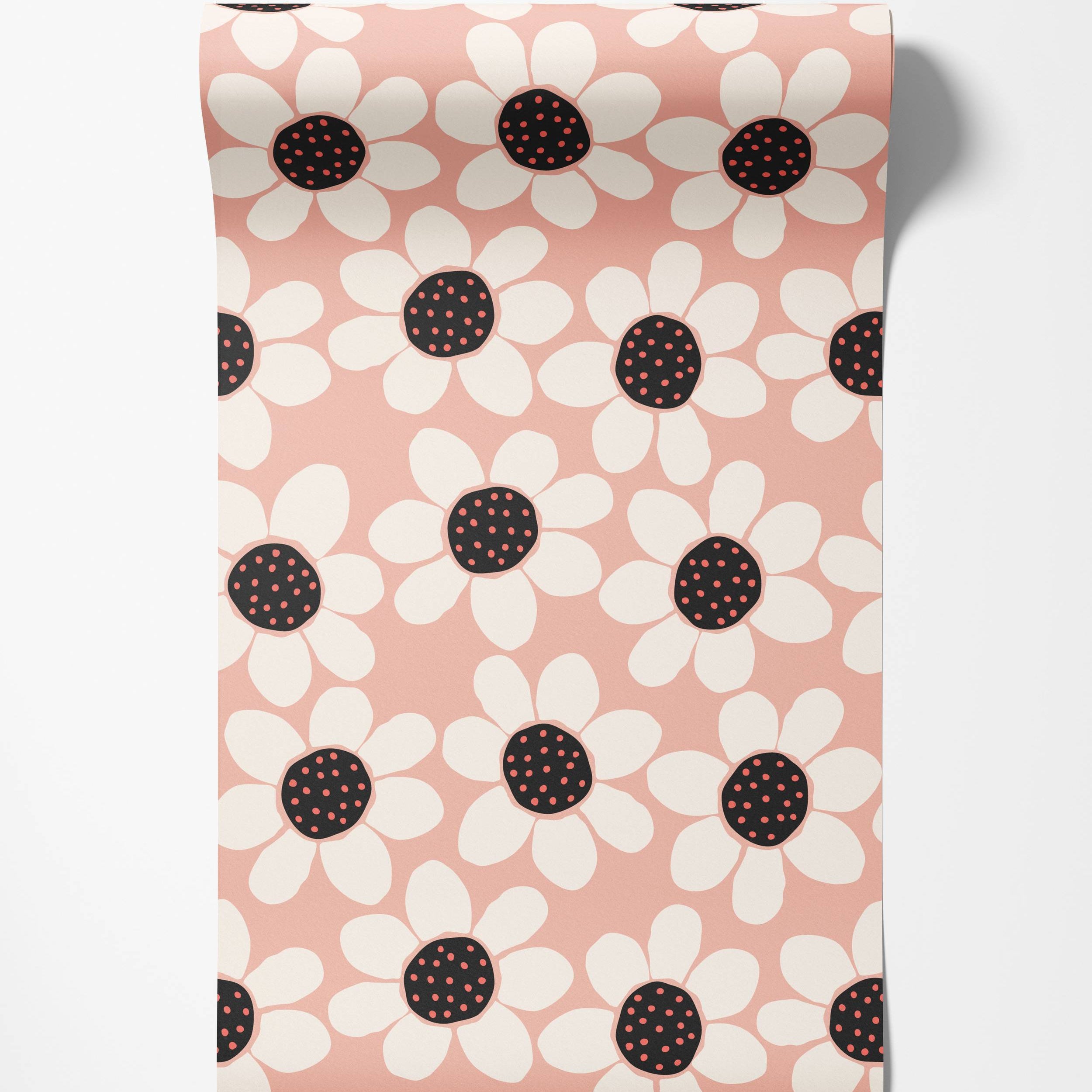 Wallpaper featuring a graphic pattern of large white daisies with black centers and red dots, on a soft pink background.