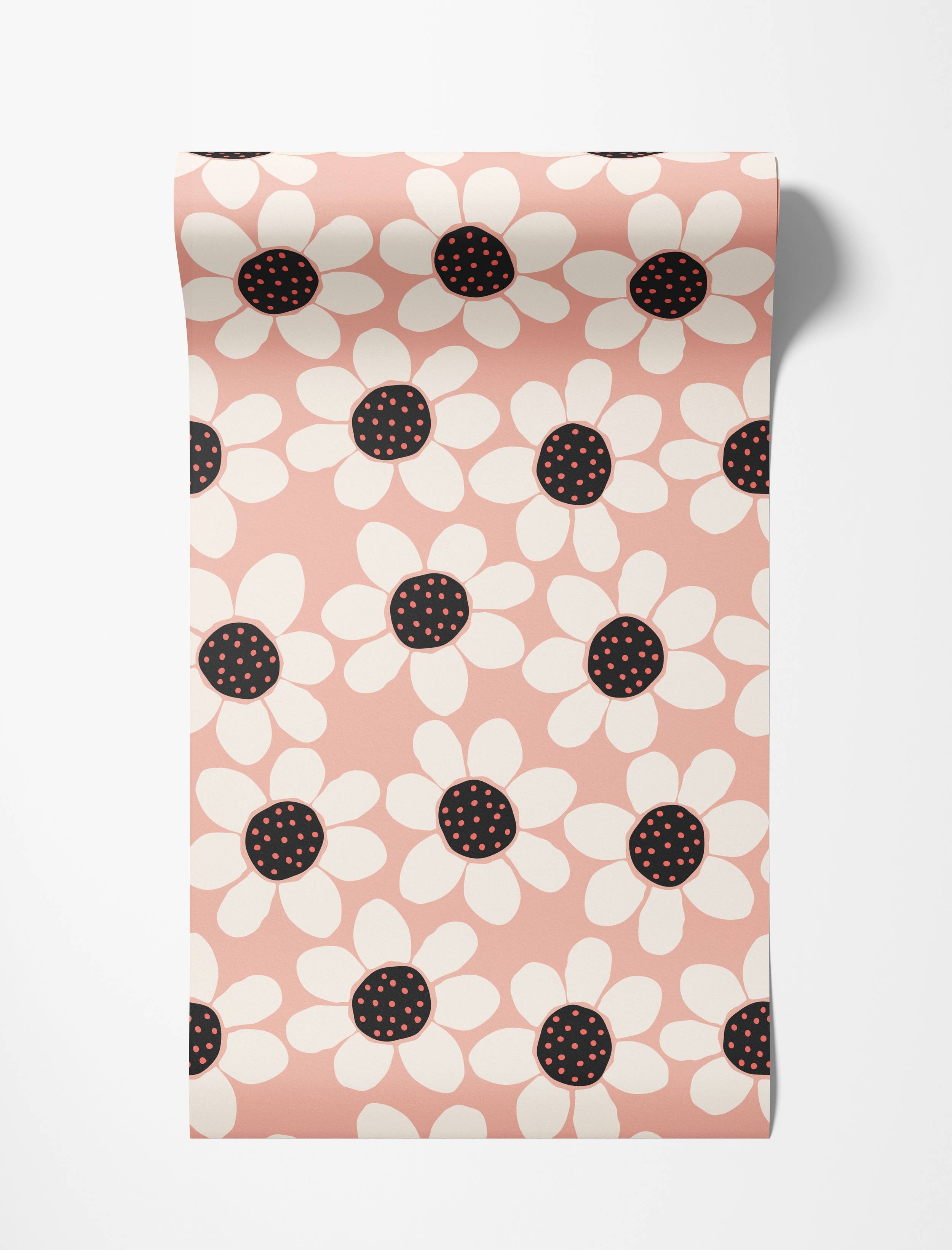 Wallpaper featuring a graphic pattern of large white daisies with black centers and red dots, on a soft pink background.