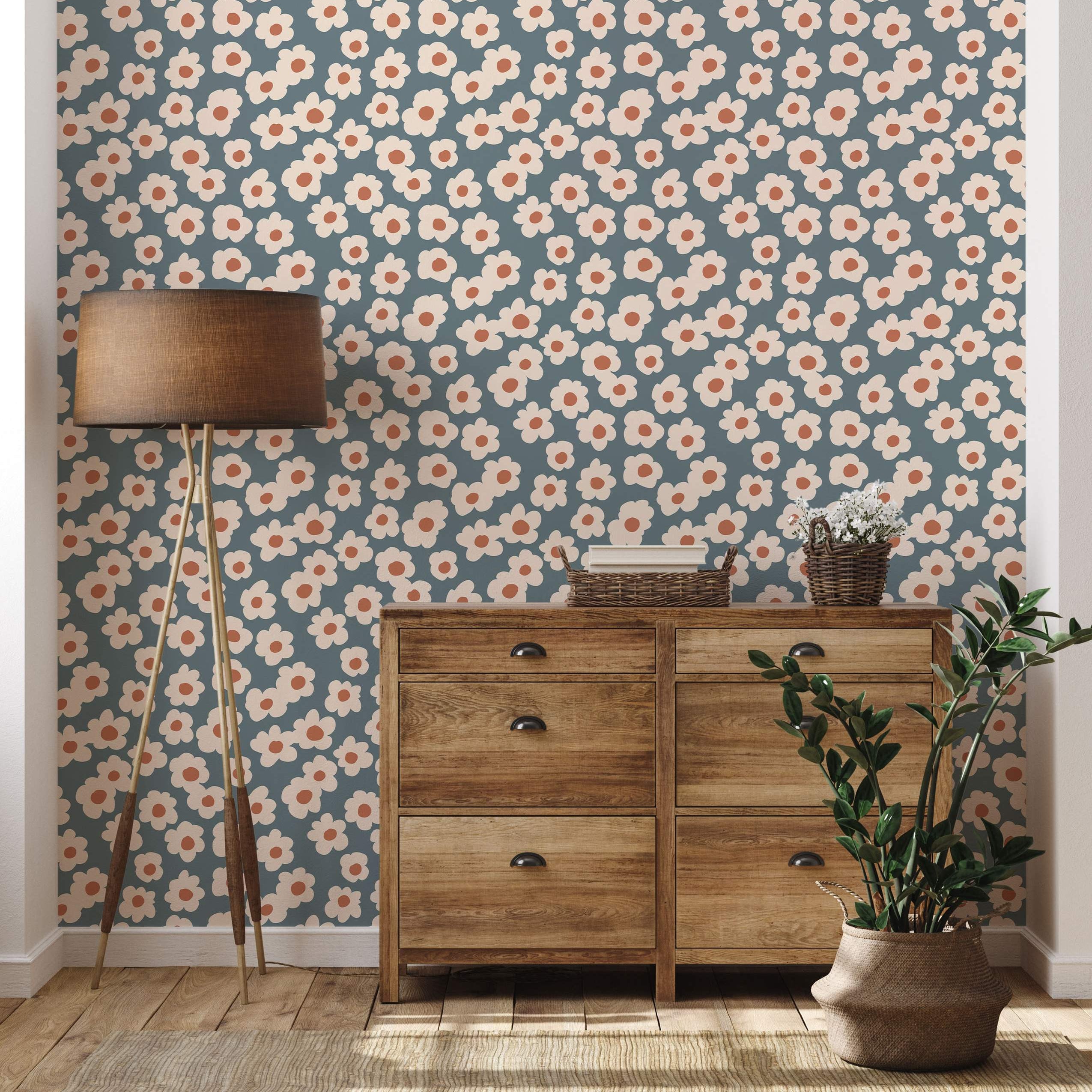 Wallpaper featuring a repeating pattern of stylized cream daisies with orange centers on a muted teal background.