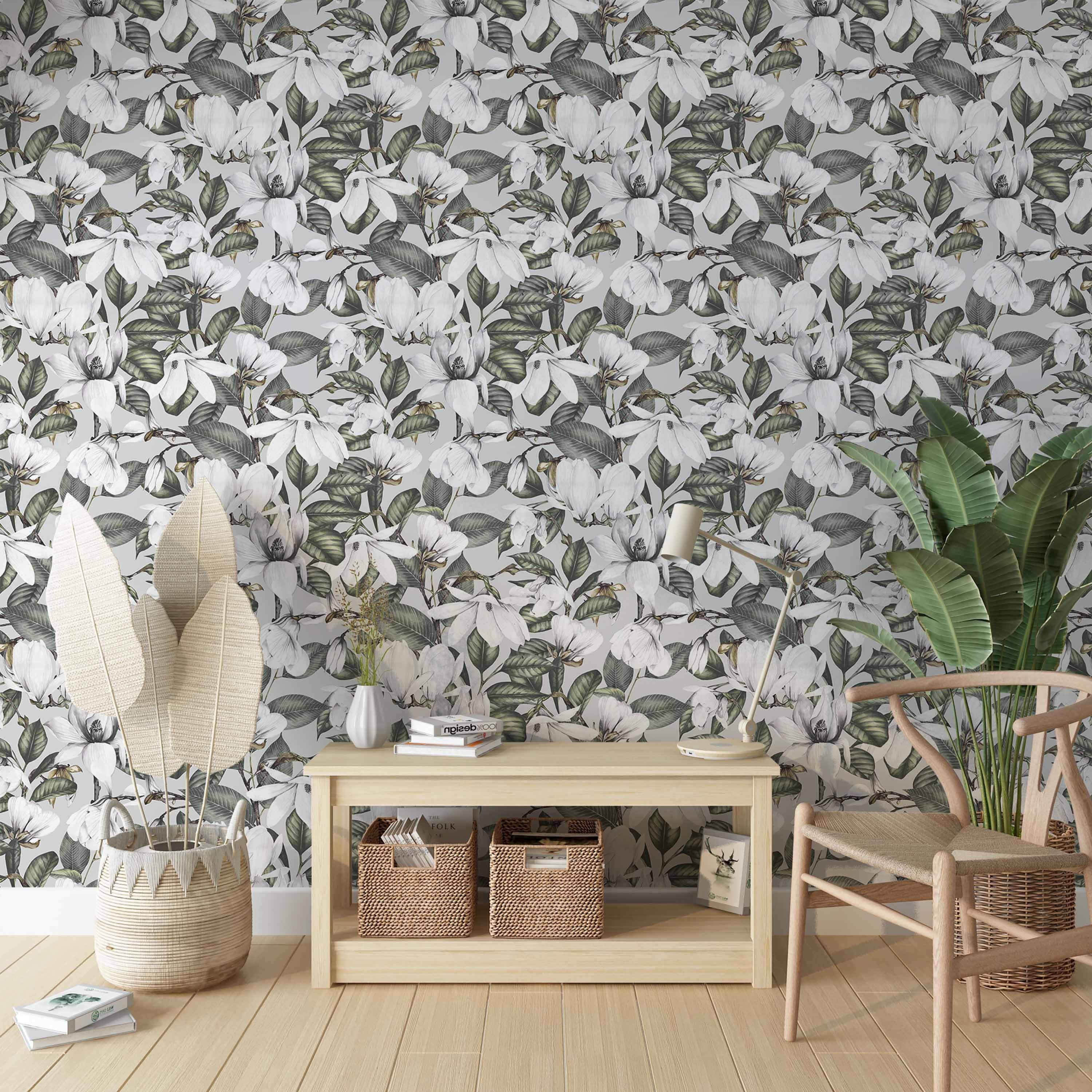 Wallpaper featuring detailed white magnolia blooms and lush green leaves scattered across a soft grey background.