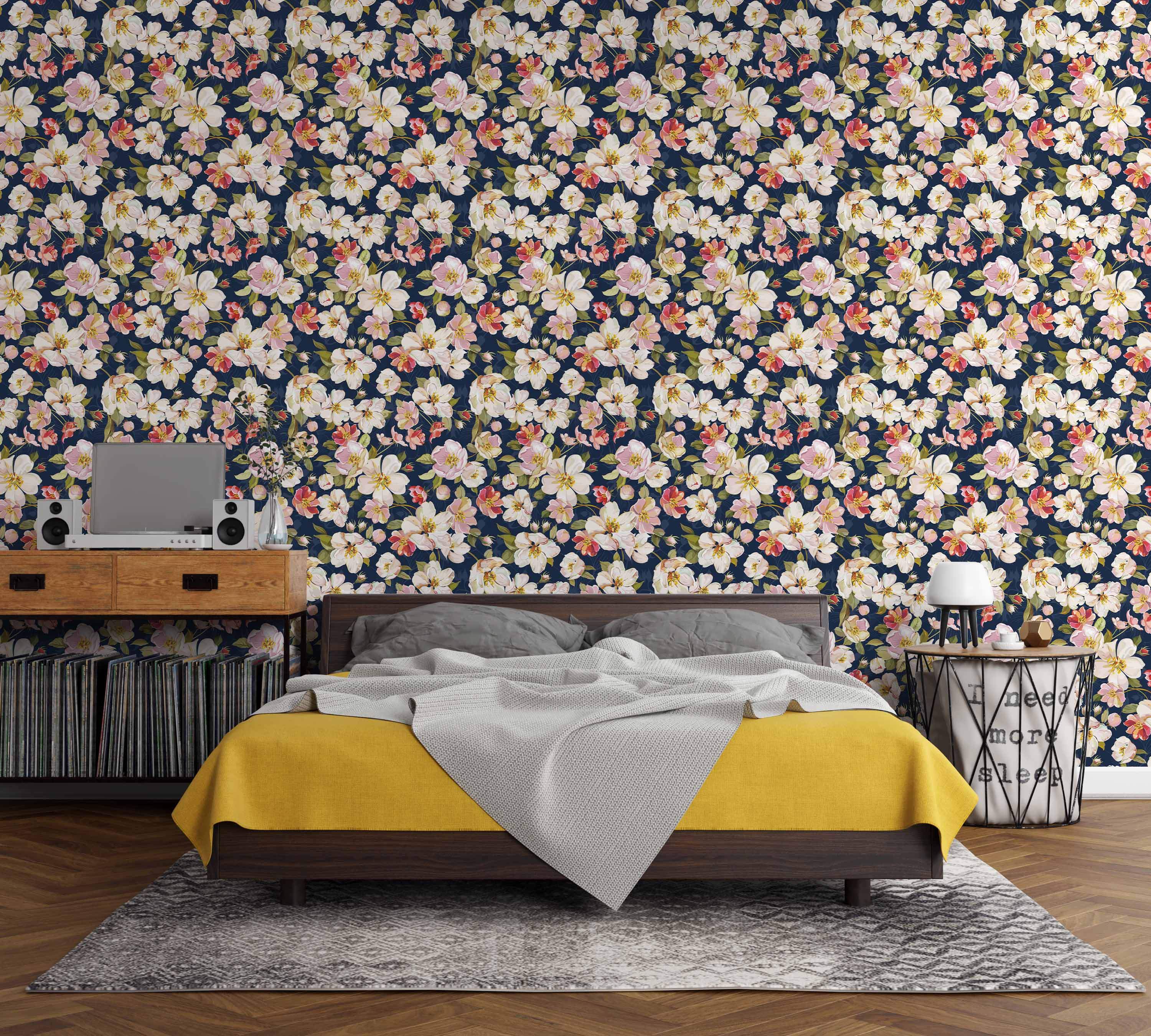 Wallpaper featuring painted white, pink, and yellow apple blossoms with green leaves scattered across a dark navy blue background.