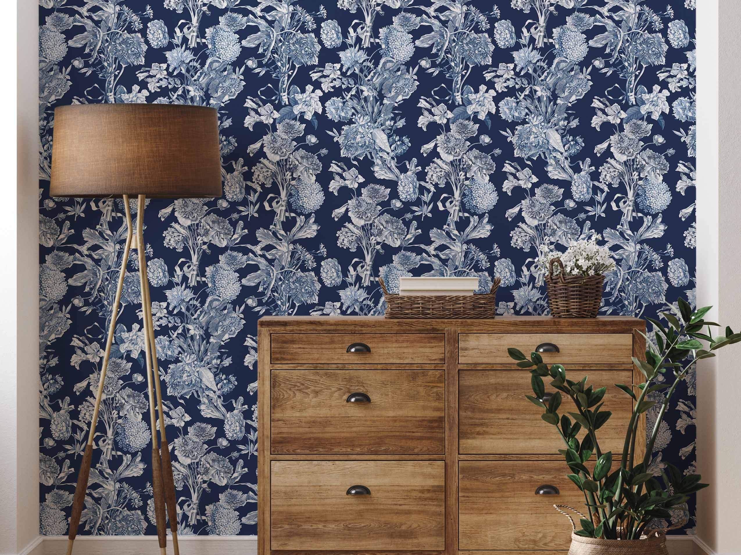 Vintage floral bouquet wallpaper in shades of white and light blue on a deep navy blue background.