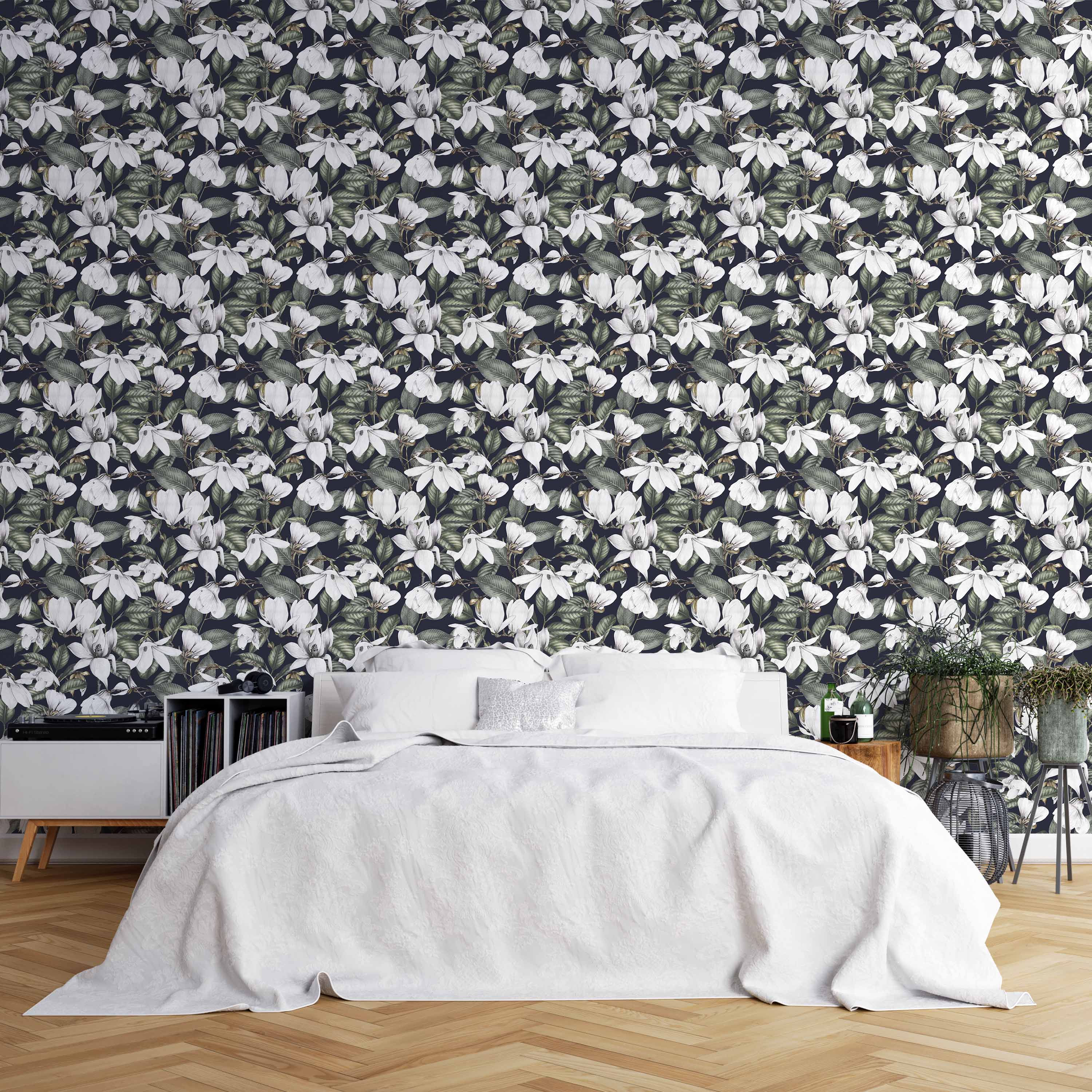 Wallpaper featuring detailed white magnolia blossoms and green leaves densely arranged on a dark navy background.