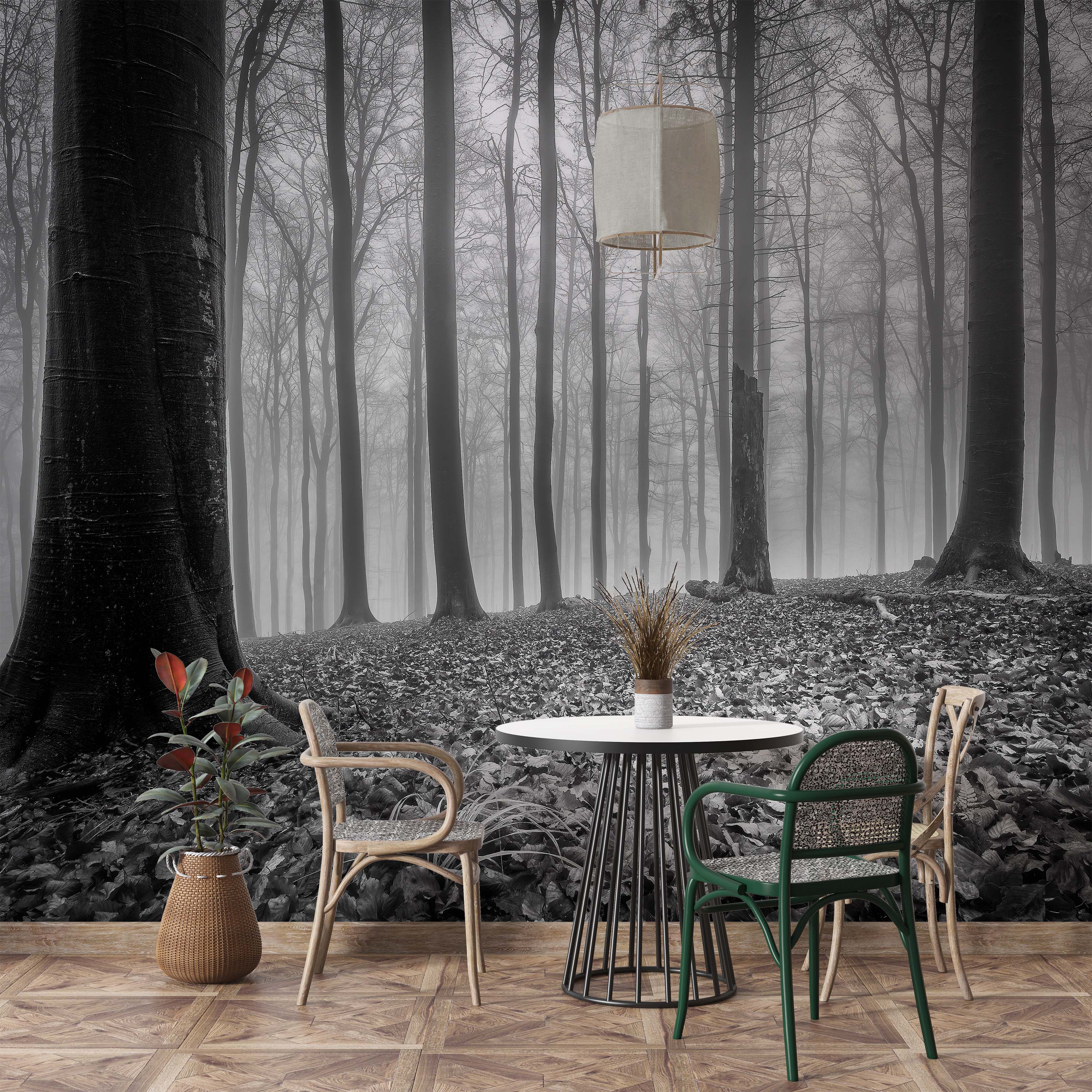 A dramatic black and white wall mural of a foggy forest with tall, bare trees and a leaf-covered ground.