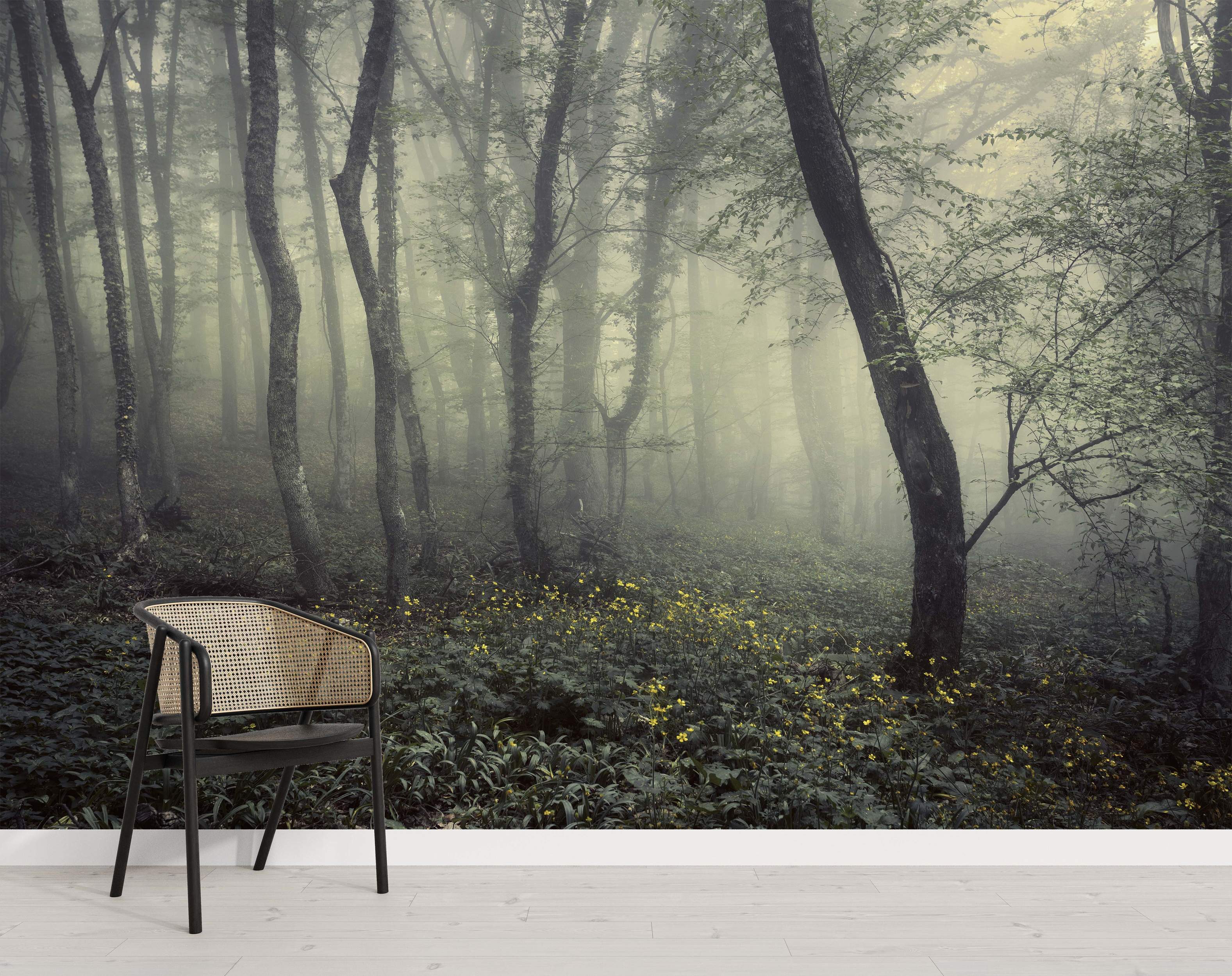 Mural depicting a misty, atmospheric forest with tall grey trees, green foliage, and small yellow flowers scattered on the ground.