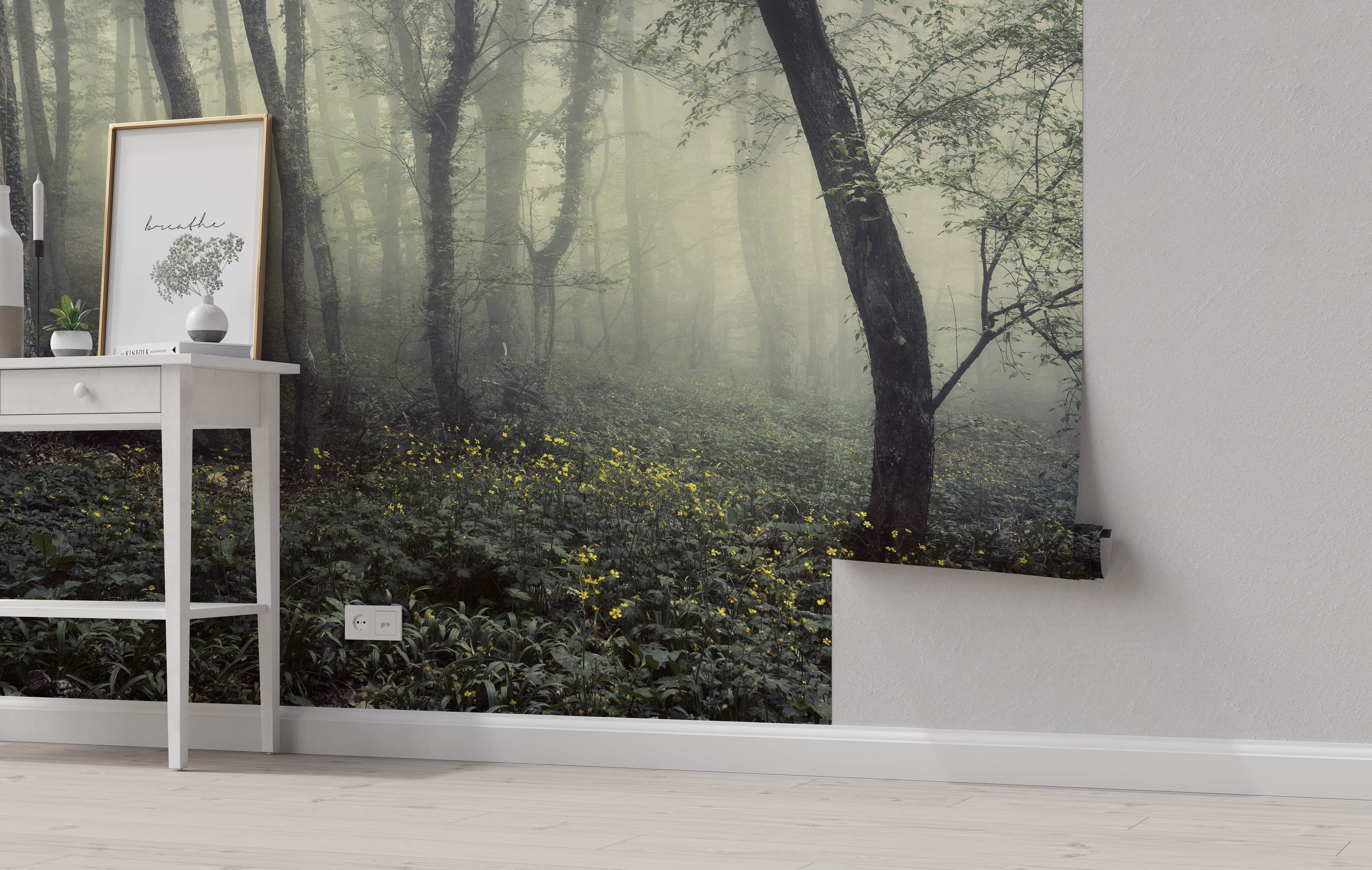 Mural depicting a misty, atmospheric forest scene with tall grey tree trunks, green foliage, yellow flowers, and dense fog.
