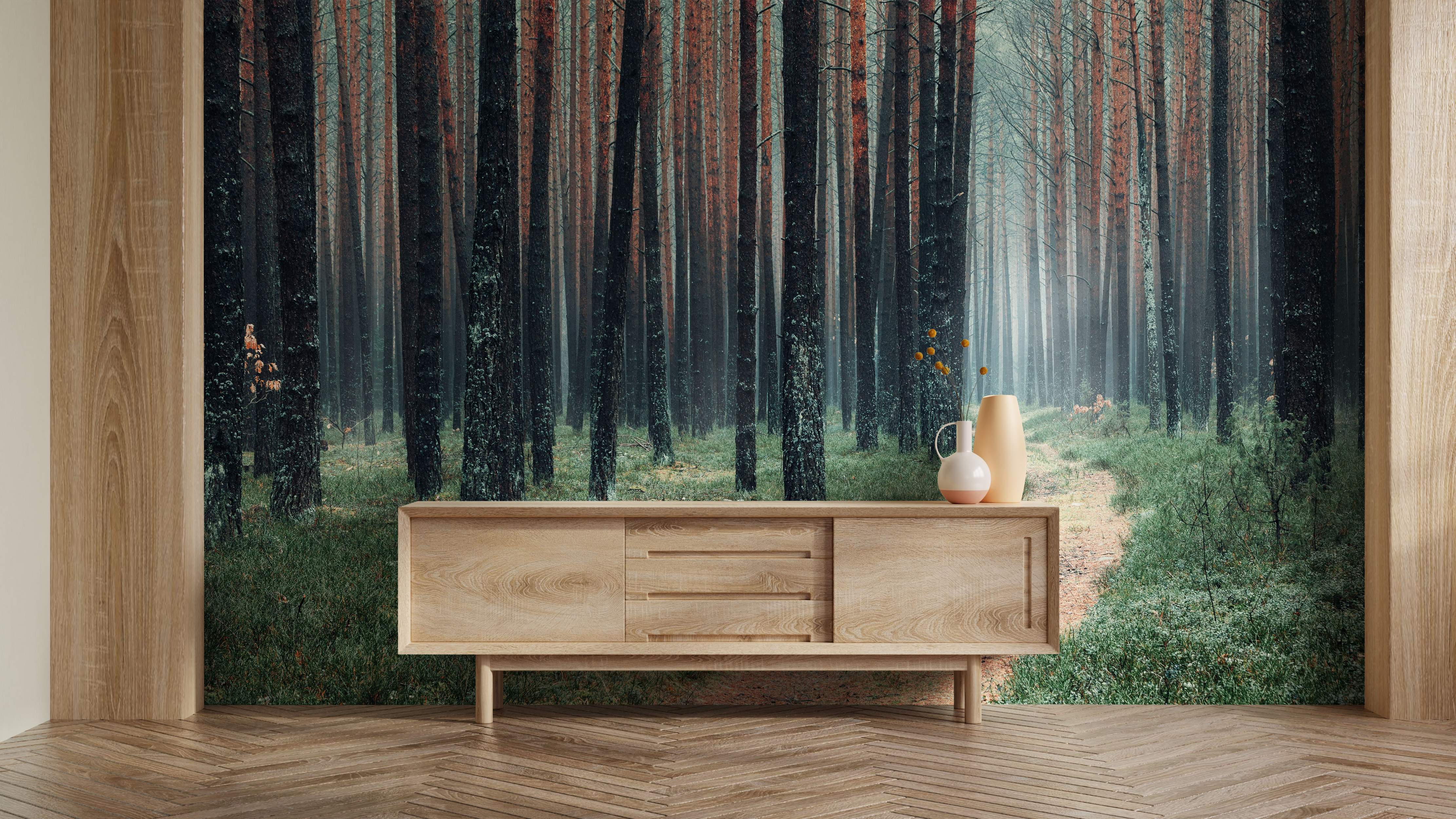 Photographic mural depicting a misty forest scene with tall, dark tree trunks, some reddish hues, and a path through green undergrowth.