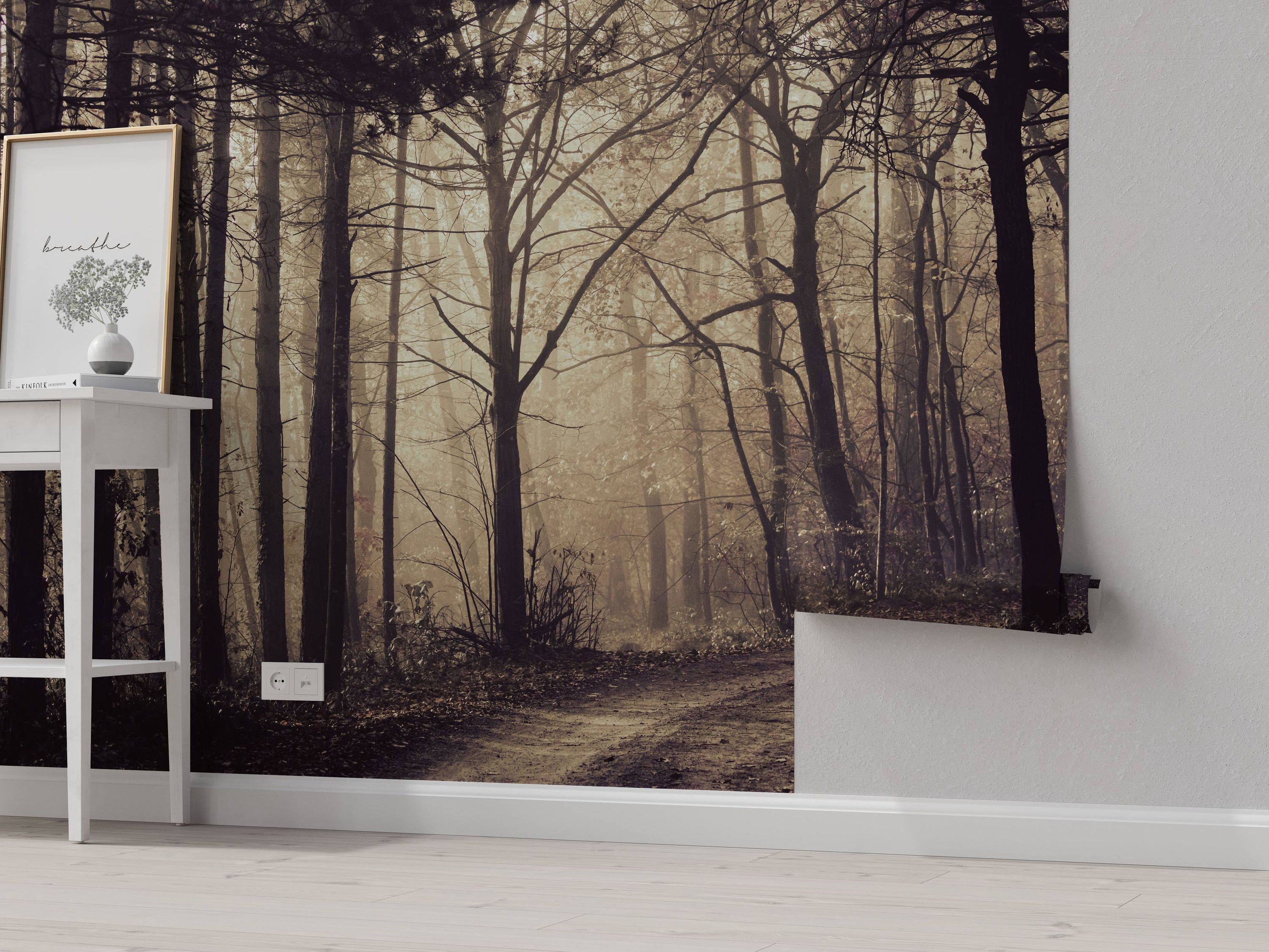 A sepia-toned mural of a dirt path winding through a dense, foggy forest with tall, bare trees creating a moody scene.