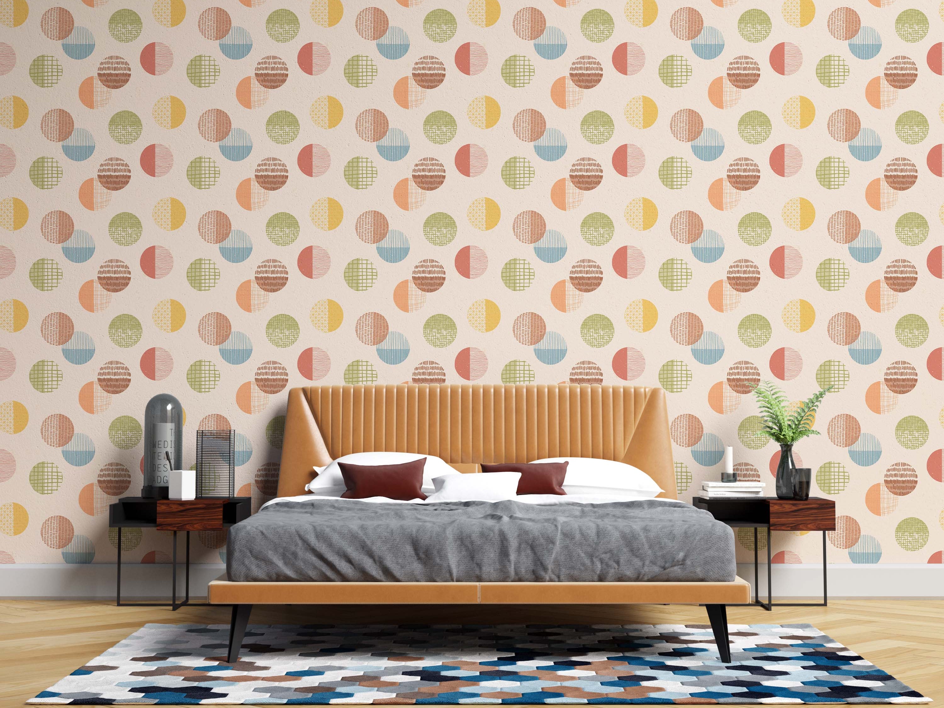 Wallpaper with a repeating pattern of textured circles in muted yellow, orange, blue, green, and brown on a light cream backdrop.