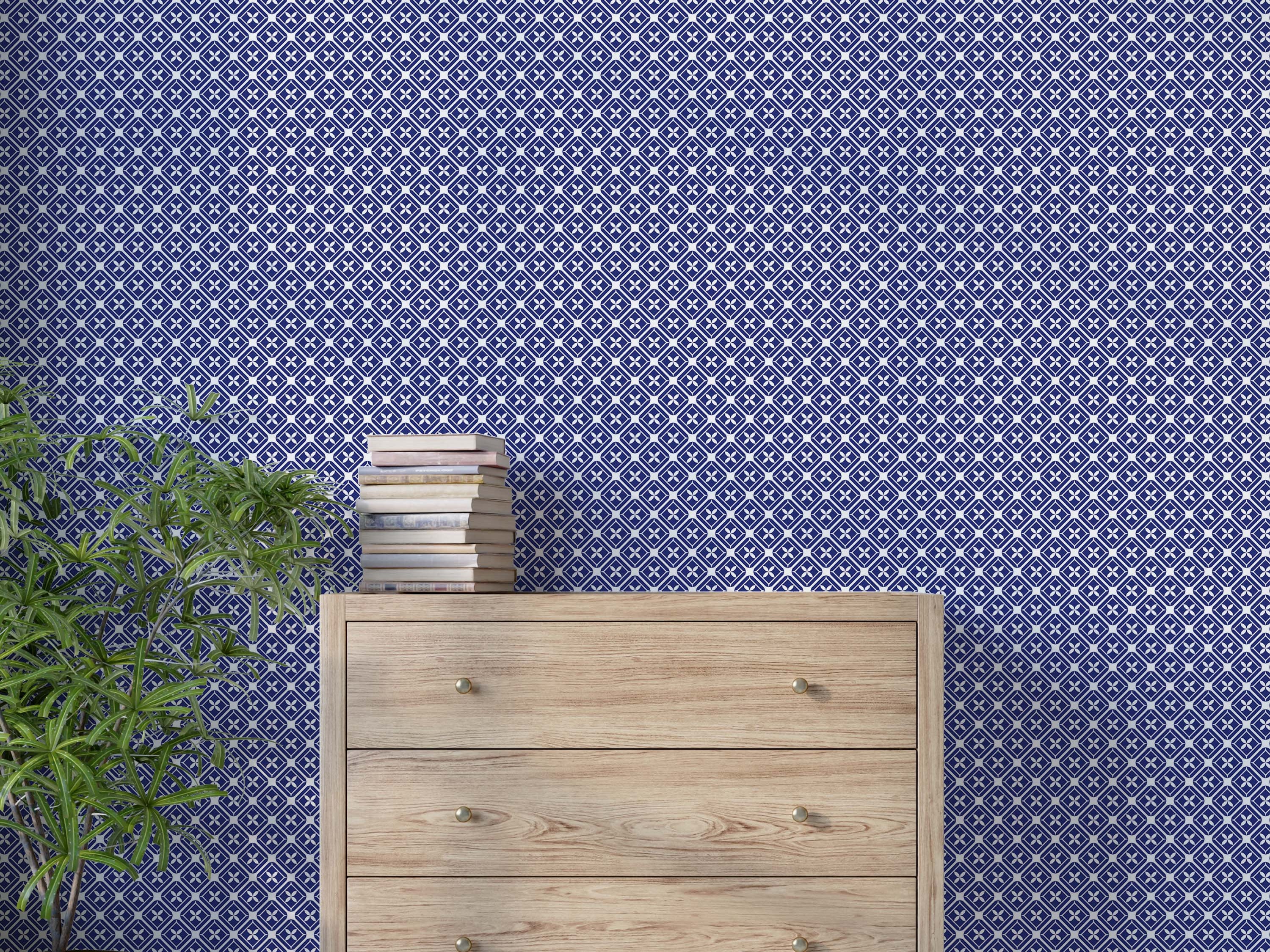 Geometric wallpaper with a repeating grid of white interlocking diamonds, each containing a stylized flower on a blue field.