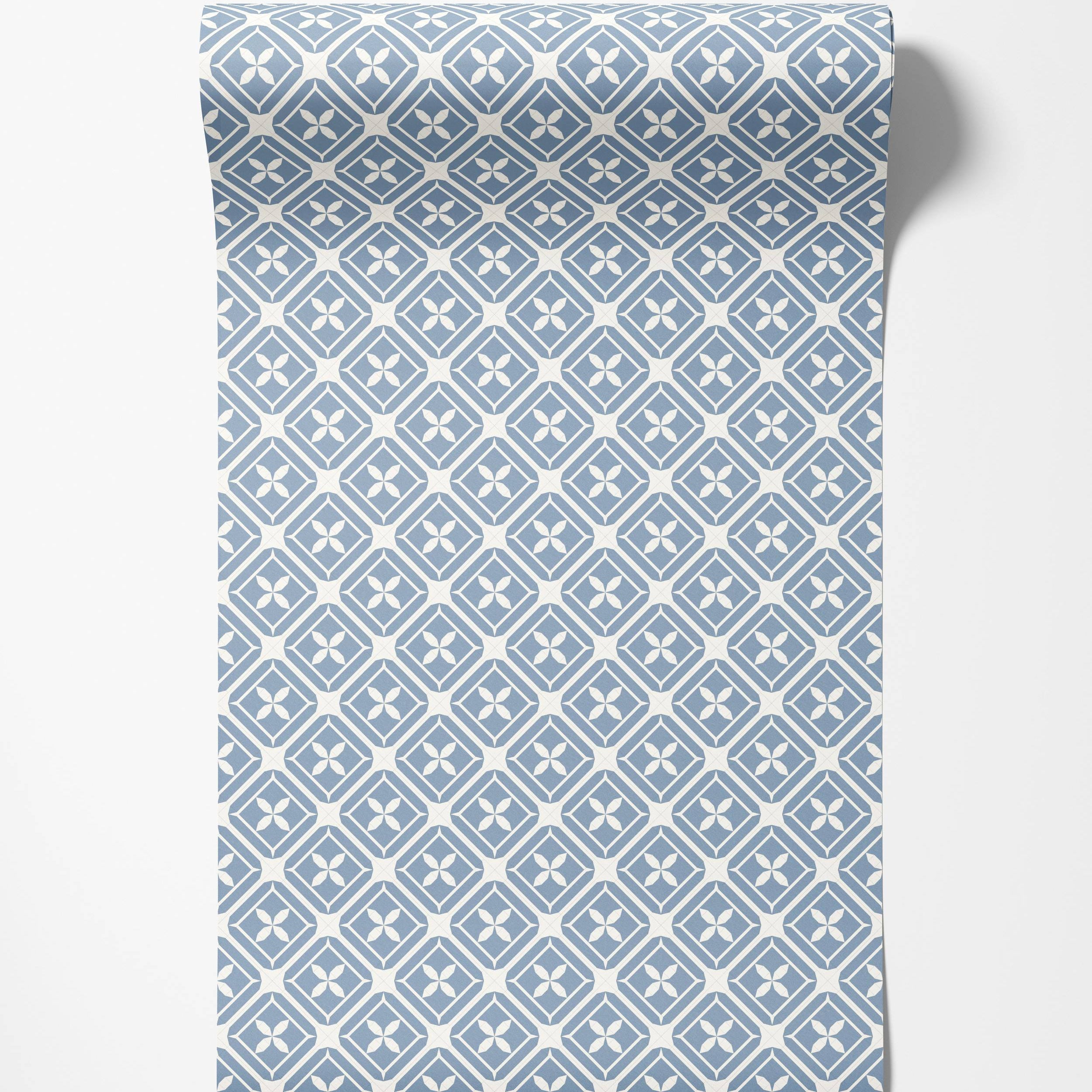 Dusty blue and off-white geometric wallpaper with a repeating pattern of diamonds enclosing four-petal flower designs.