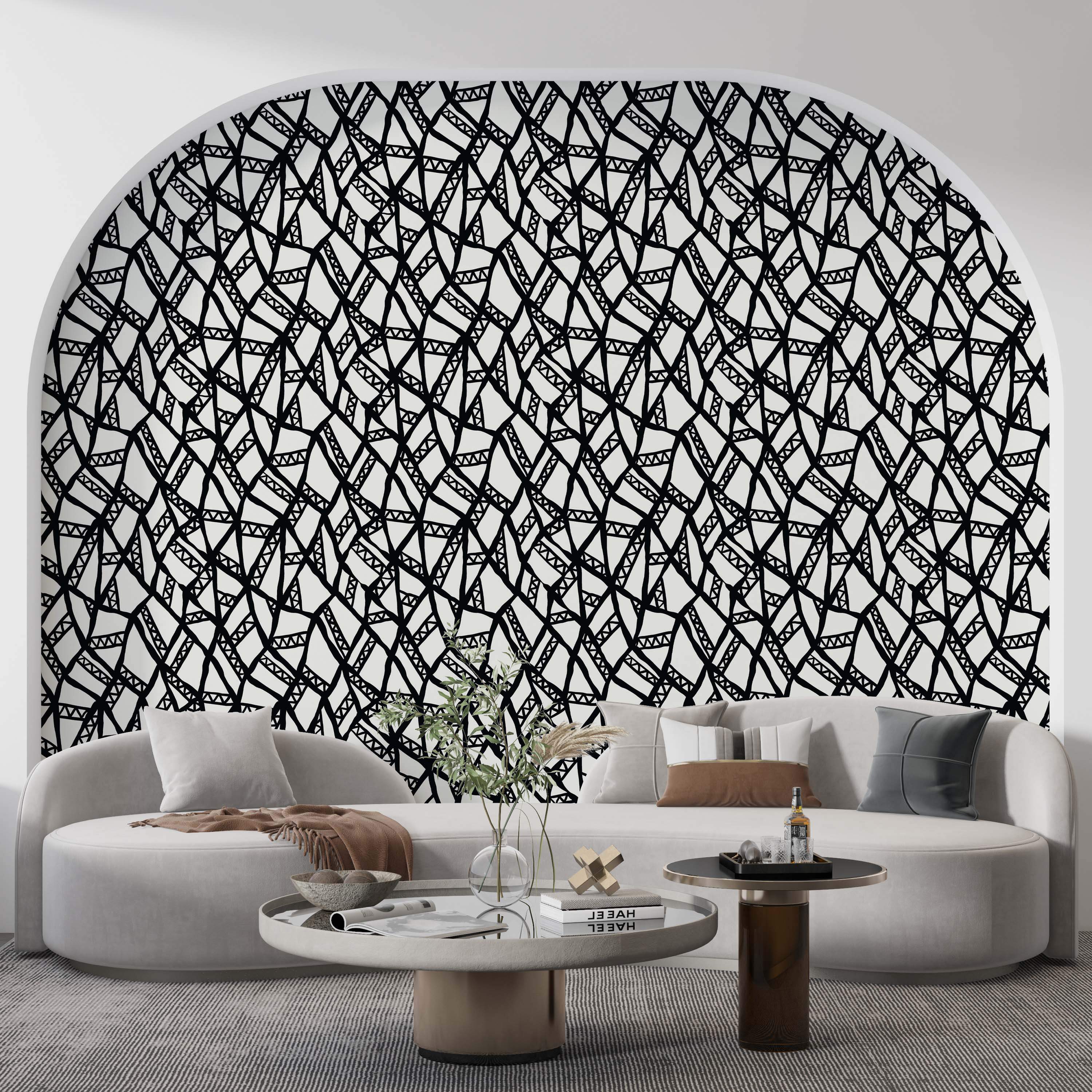 Black and cream wallpaper with a hand-drawn geometric pattern of intersecting lines and shapes.