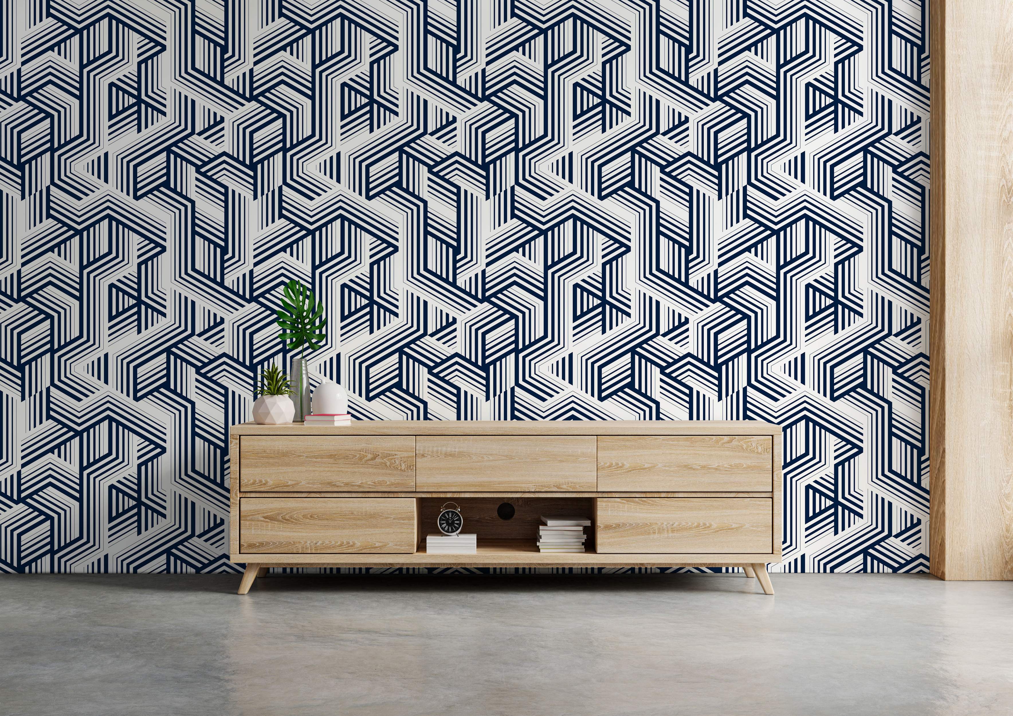 Geometric wallpaper with interlocking angular lines in navy blue and off-white, creating a complex, maze-like pattern.