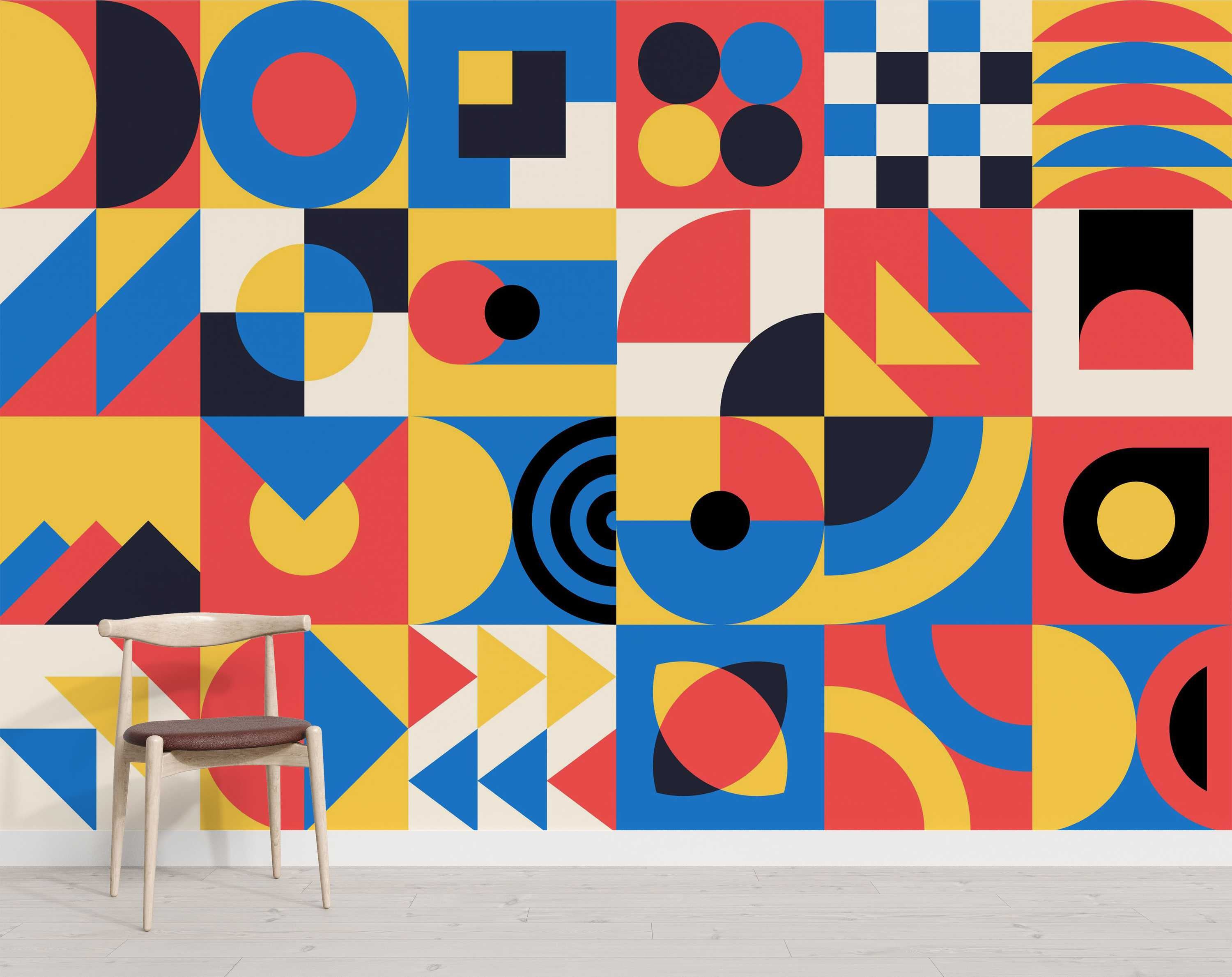 Geometric mural composed of block patterns with circles, squares, and triangles in primary colors red, blue, yellow, plus black and beige.