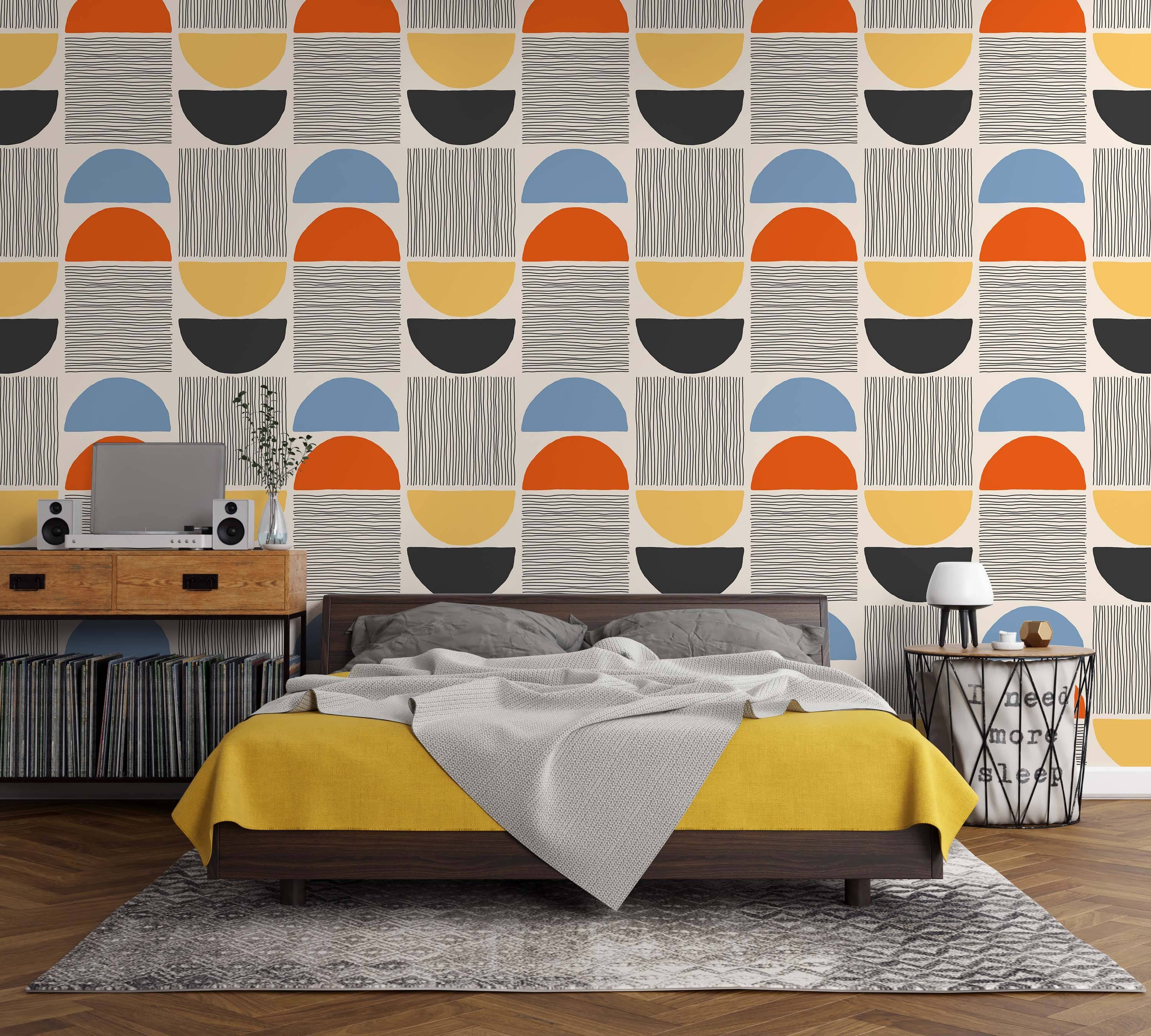 Geometric wallpaper with blue, orange, yellow, black semi-circles and lined squares in a repeating block pattern on beige.