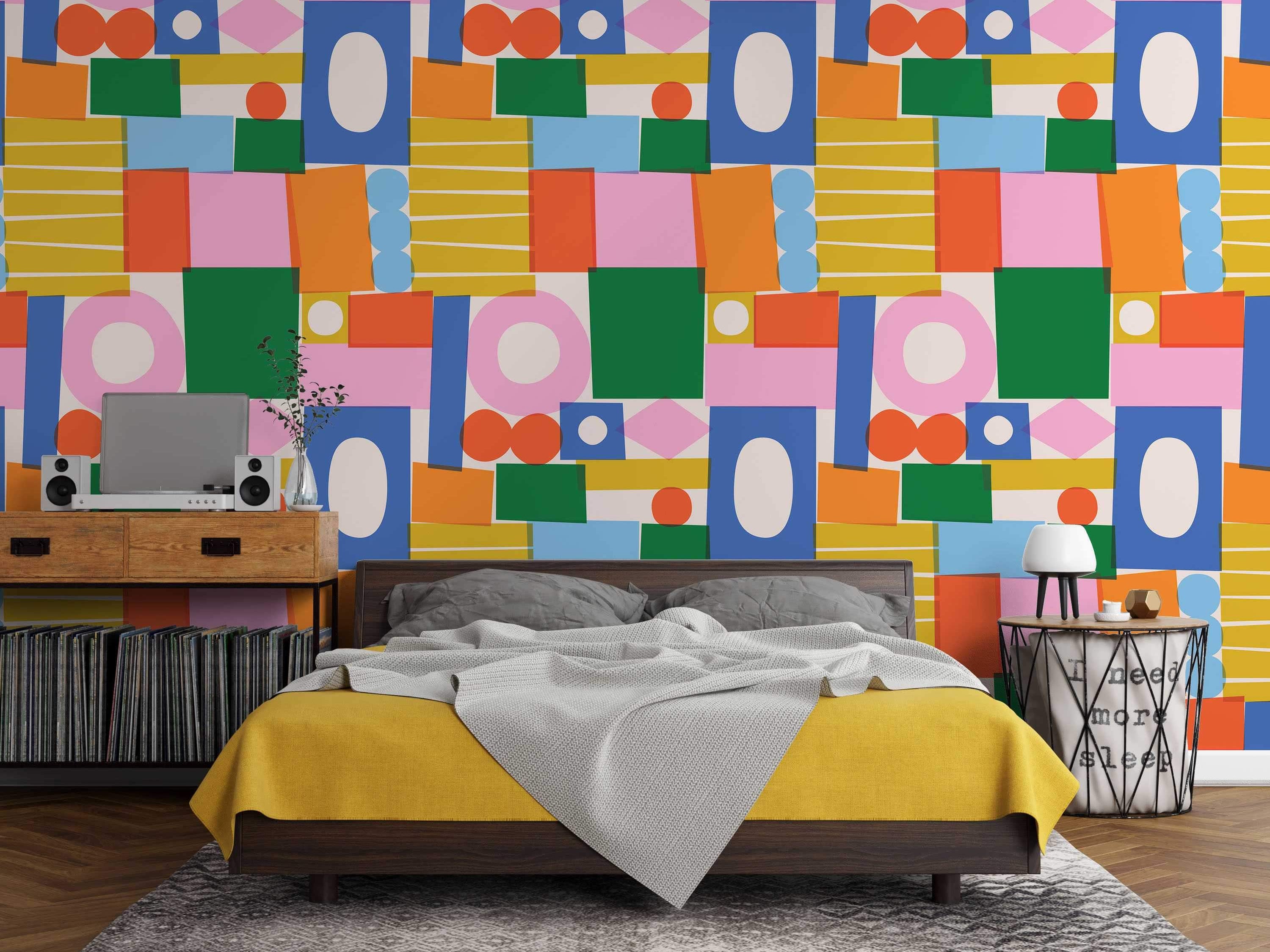 Abstract wallpaper featuring overlapping geometric shapes in blue, green, pink, orange, and yellow on a light background.