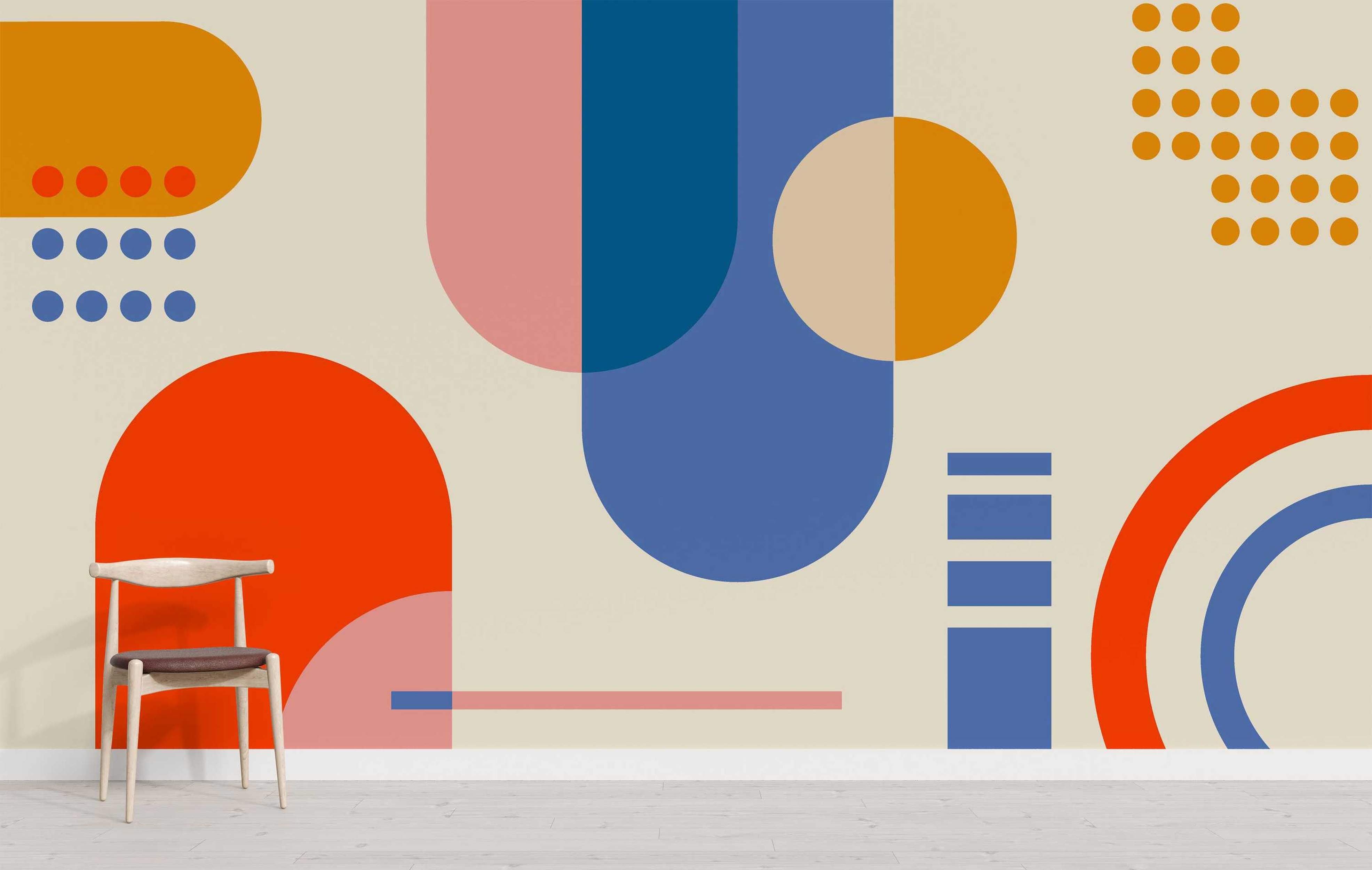 Abstract geometric mural with large overlapping shapes like circles, semi-circles, and dots in orange, blue, pink on a beige wall.