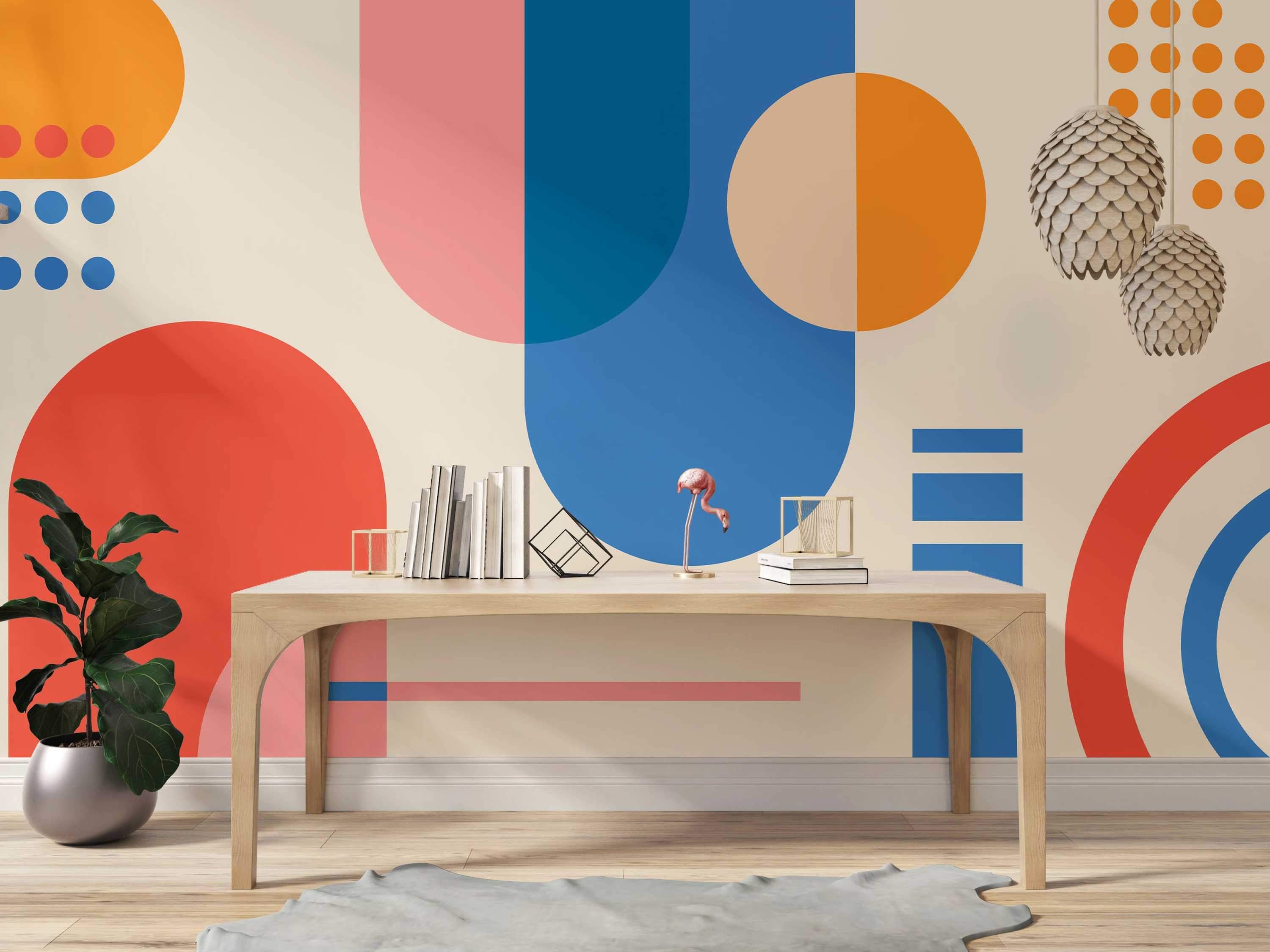 Geometric mural featuring large, overlapping circles, semi-circles, and rectangles in orange, red, blue, and pink on beige.