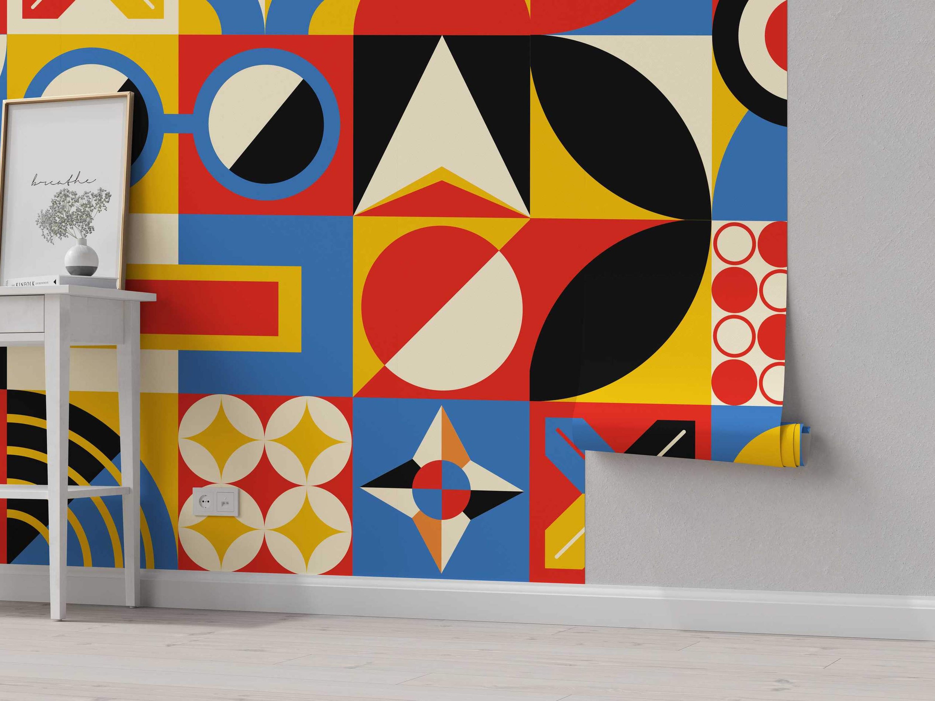 Geometric wallpaper with a grid pattern featuring circles, triangles, and abstract shapes in bold red, blue, yellow, black, and cream.