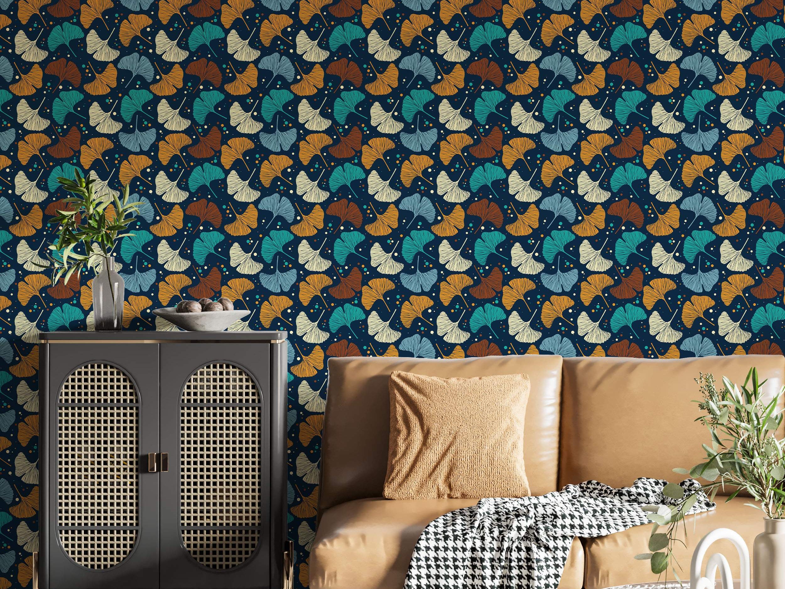 Wallpaper with stylized Ginkgo leaves in teal, orange, brown, light blue, and cream scattered on a dark navy blue background.