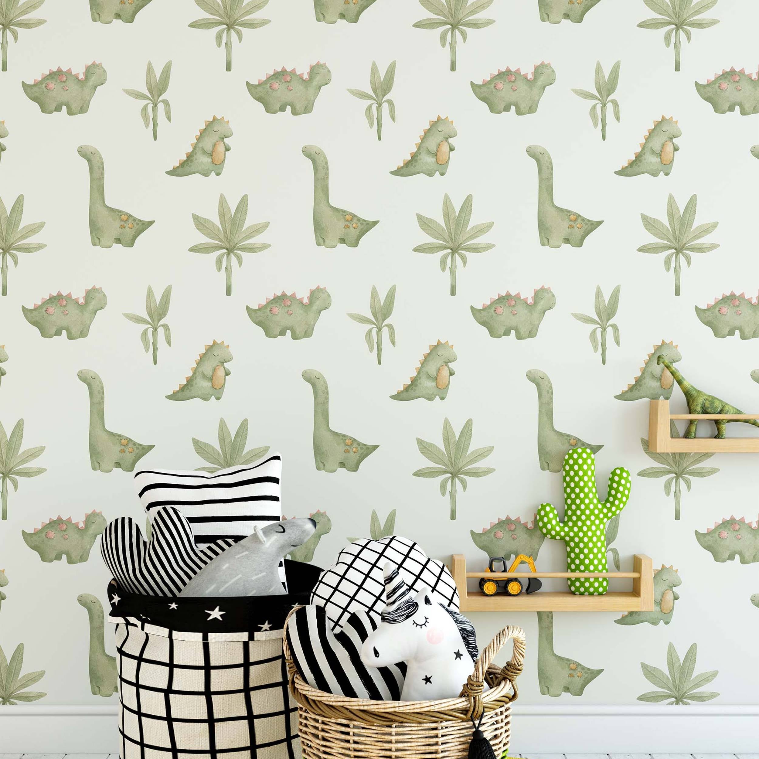 Wallpaper with a repeating pattern of cute green cartoon dinosaurs and simple green plants on a light cream background.