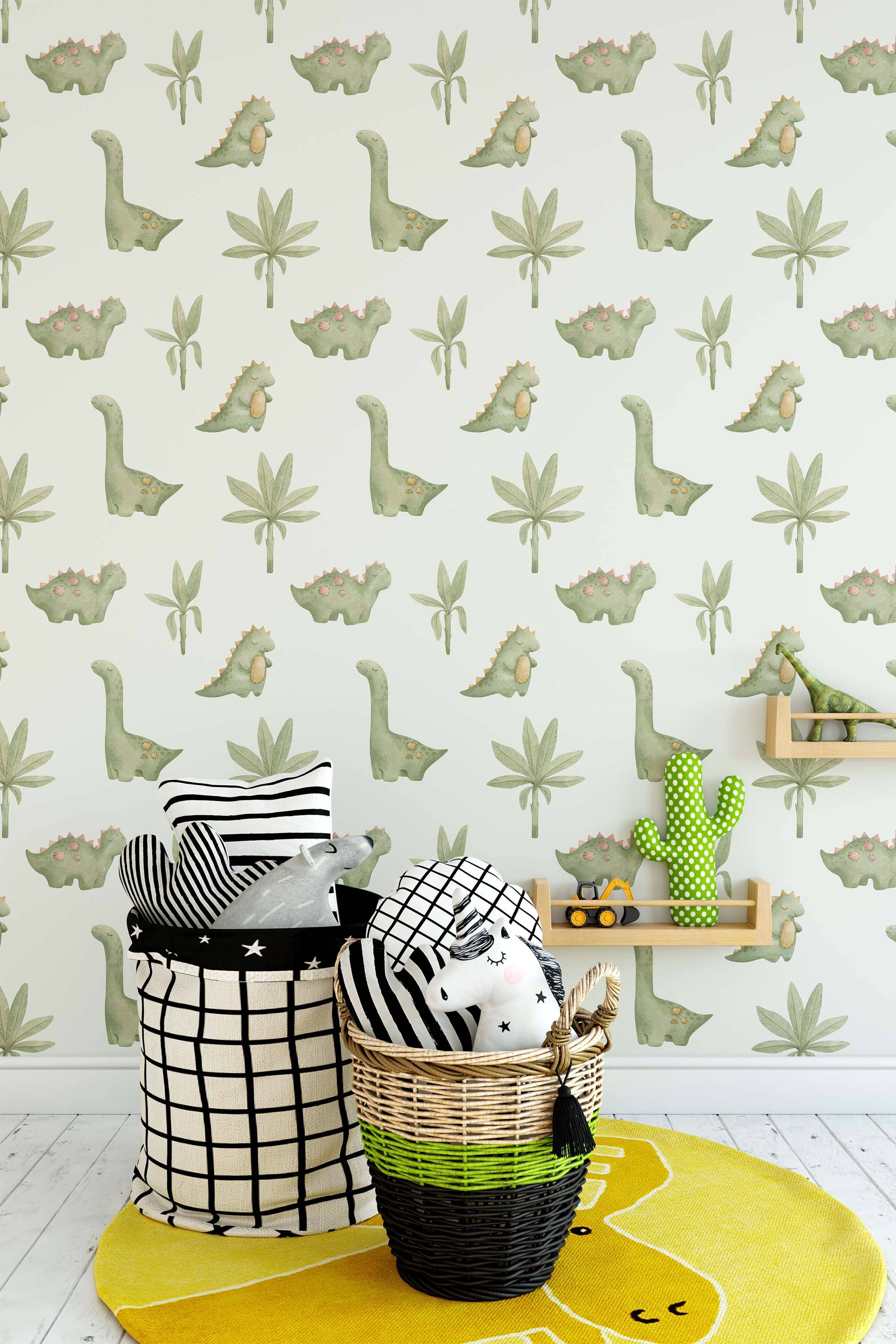 Wallpaper with a repeating pattern of cute green cartoon dinosaurs and simple green plants on a light cream background.