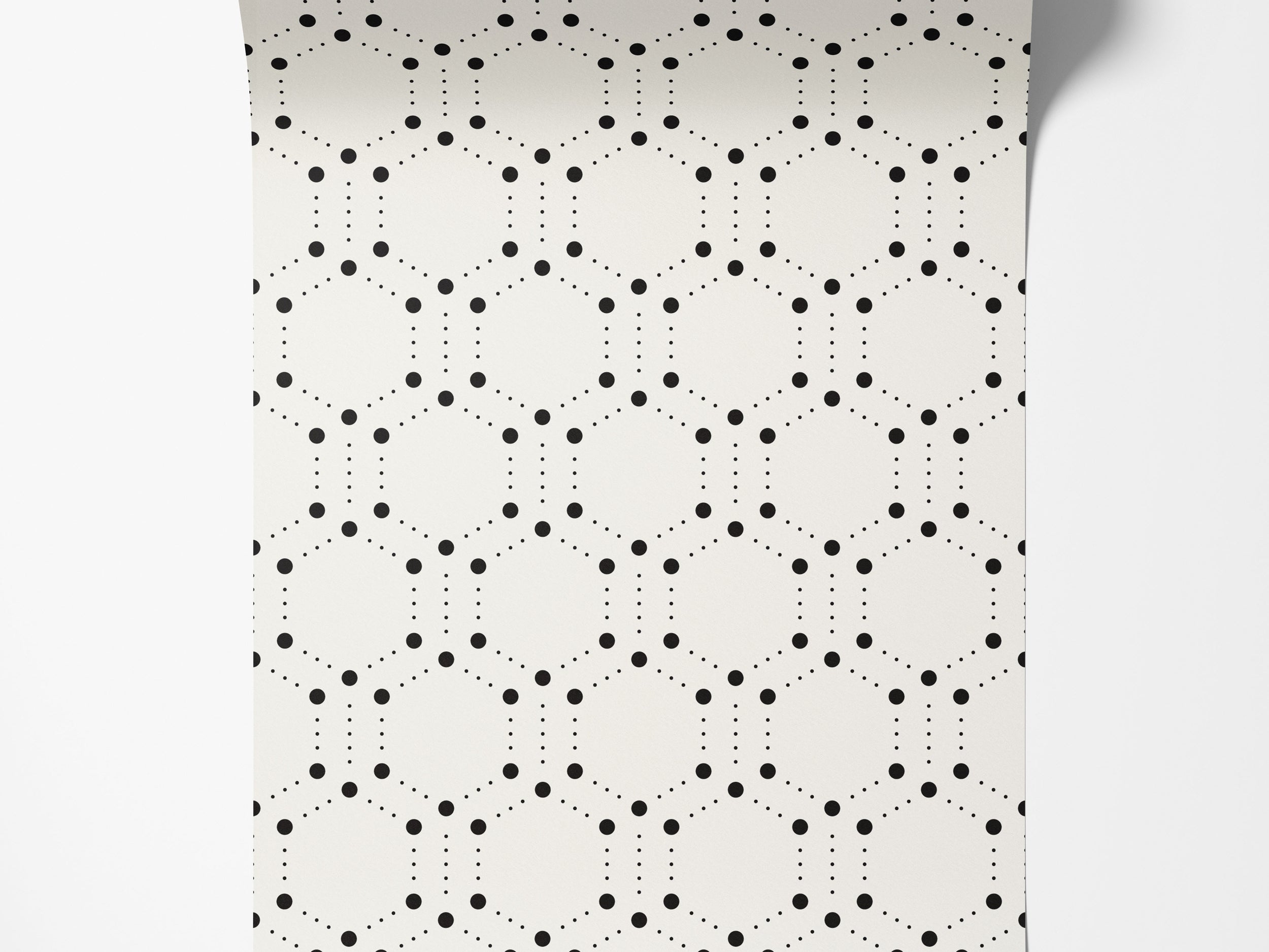 Geometric wallpaper featuring hexagons outlined by large and small black dots on a cream background.