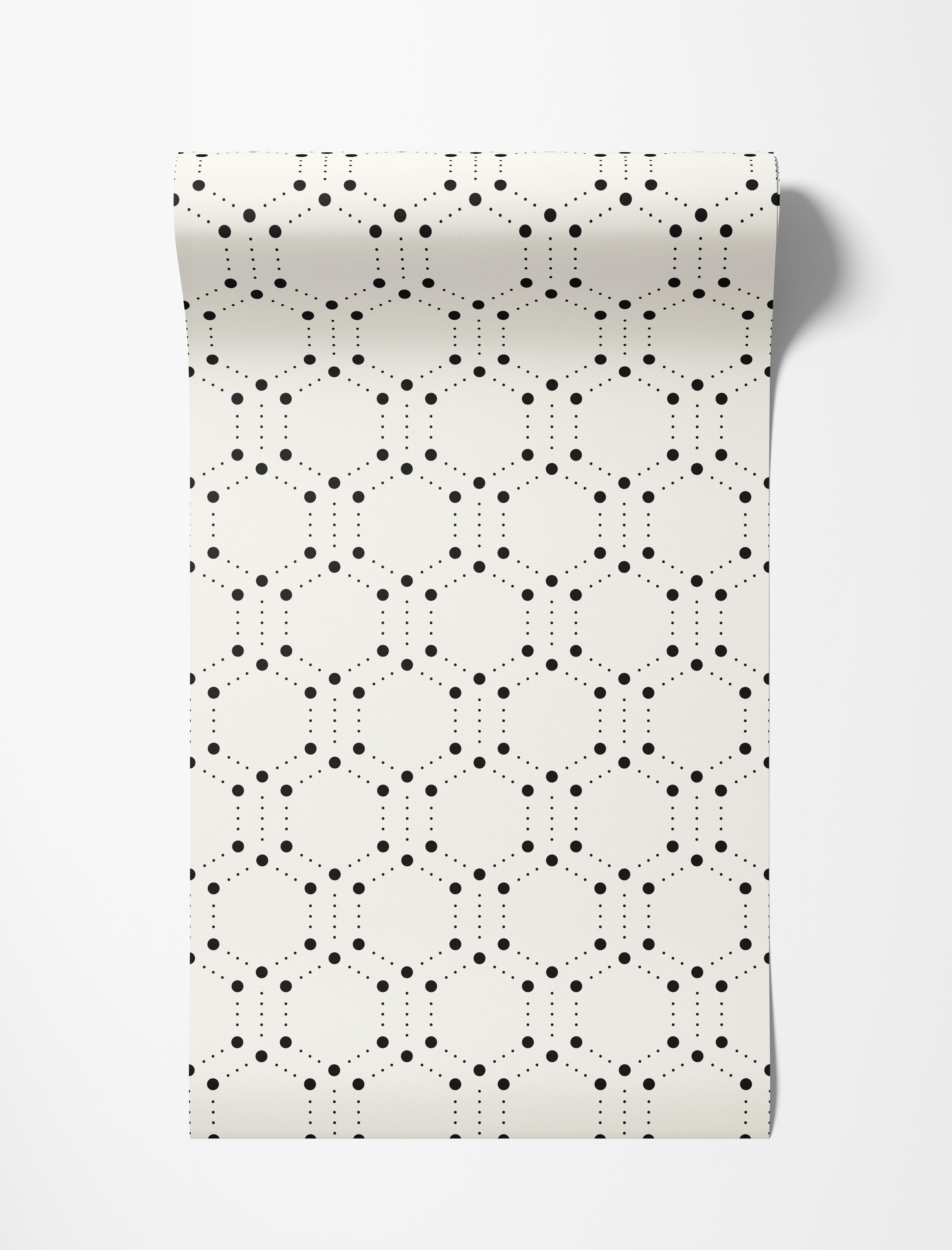 Geometric wallpaper featuring hexagons outlined by large and small black dots on a cream background.