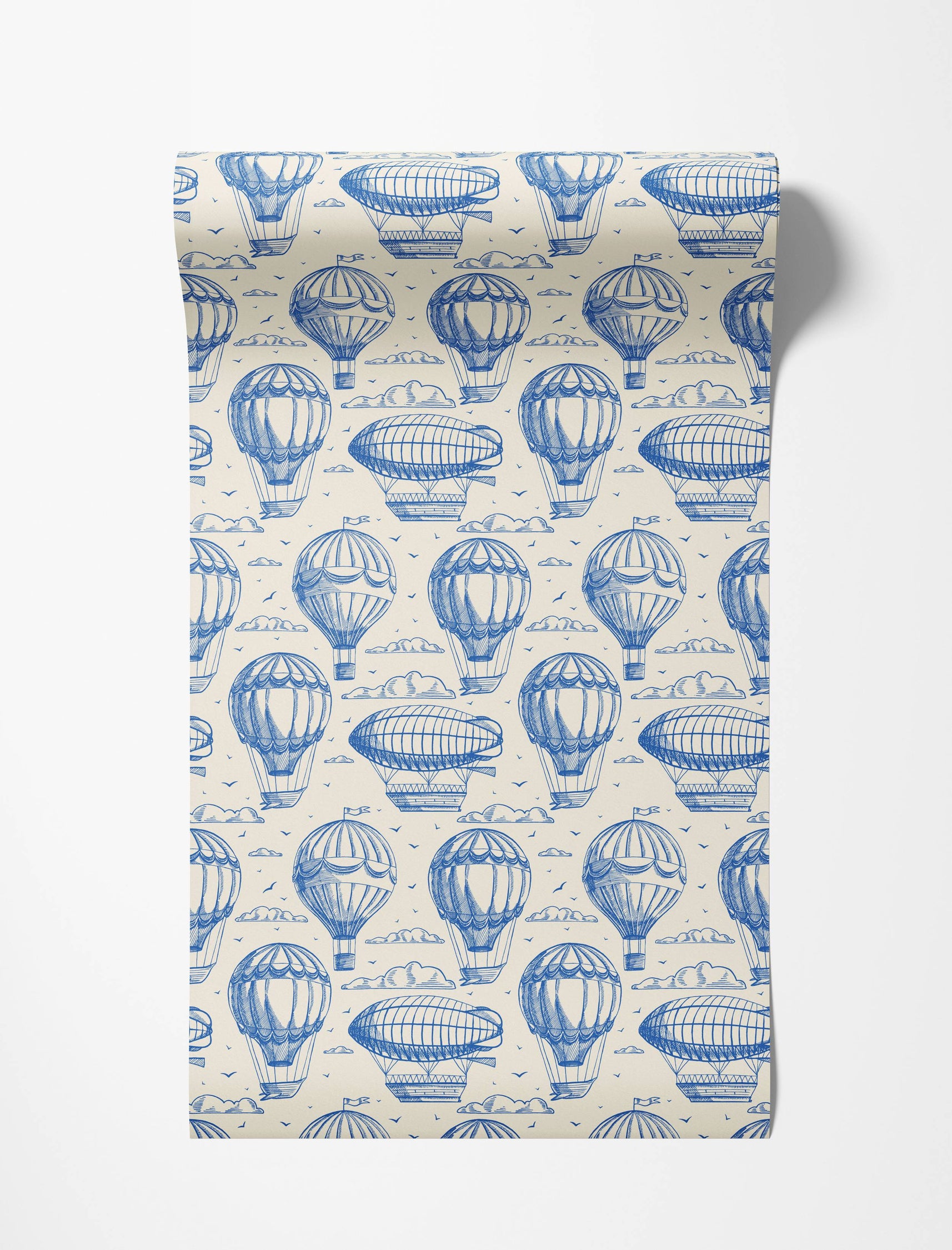 Vintage-style wallpaper with a repeating pattern of blue sketched hot air balloons, zeppelins, and clouds on a cream background.