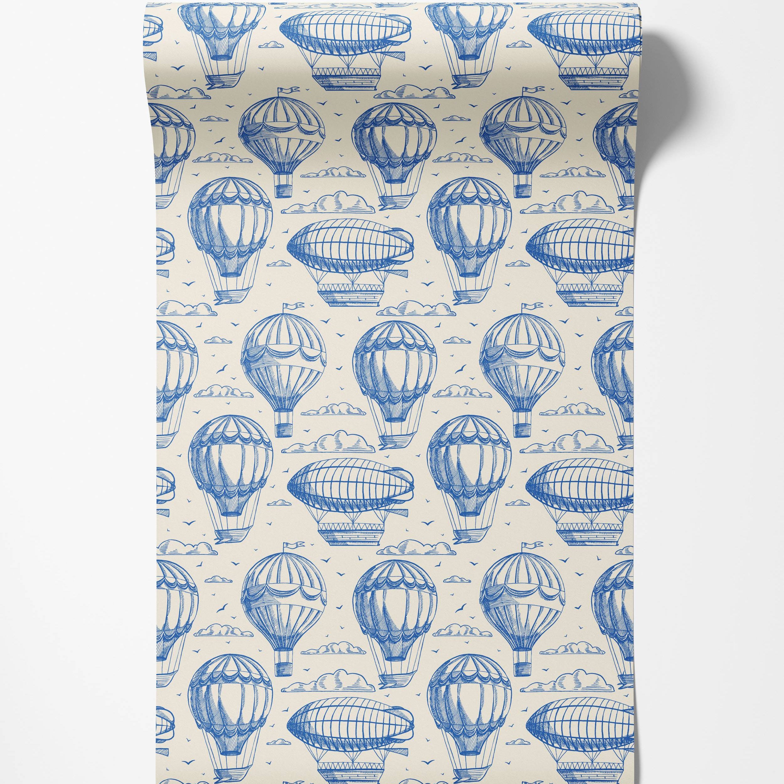 Vintage-style wallpaper with a repeating pattern of blue sketched hot air balloons, zeppelins, and clouds on a cream background.