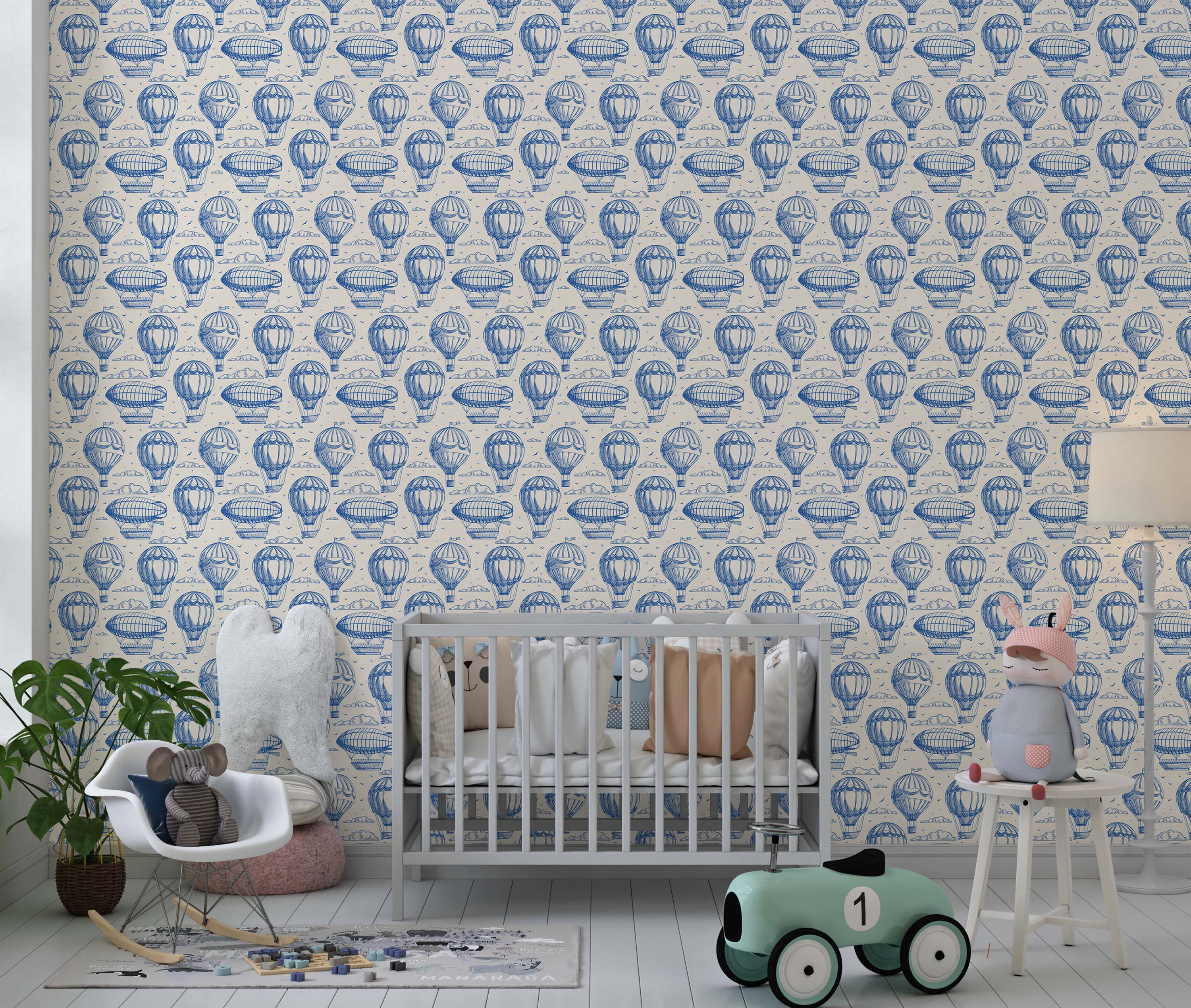 Vintage wallpaper with a blue sketch pattern of hot air balloons and zeppelins on a cream background.