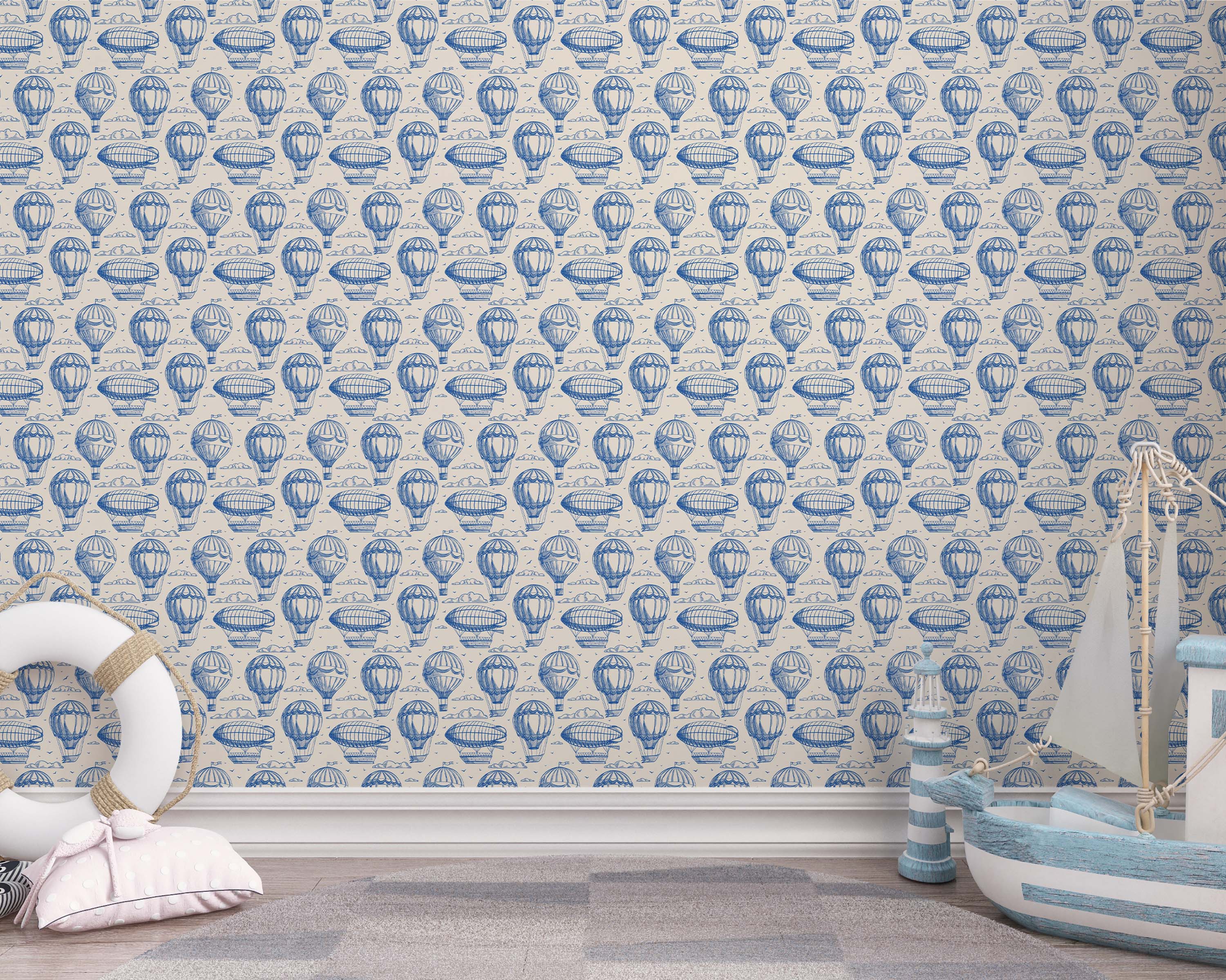 Vintage wallpaper with a repeating pattern of blue illustrated hot air balloons and zeppelins on a cream background.