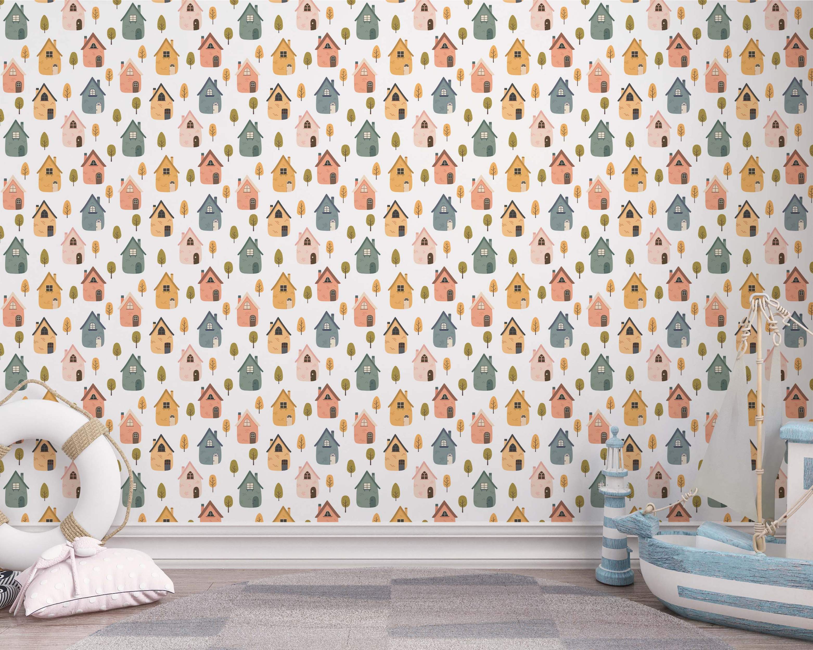 Wallpaper featuring a repeating pattern of stylized houses and trees in muted pink, yellow, blue-grey, and green tones.