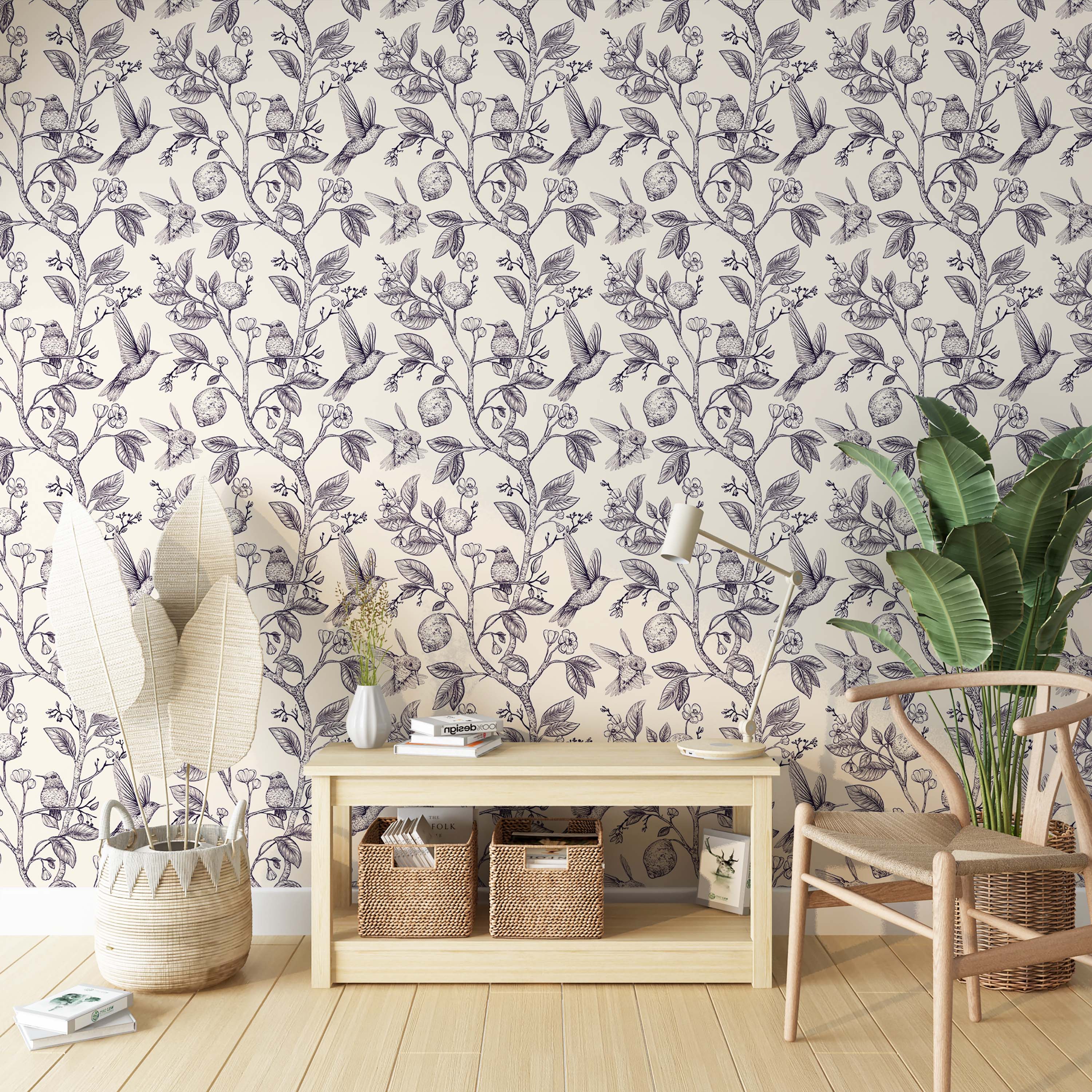 Wallpaper with a navy blue sketch-style pattern of hummingbirds, lemons, and flowers on branches, over a cream background.