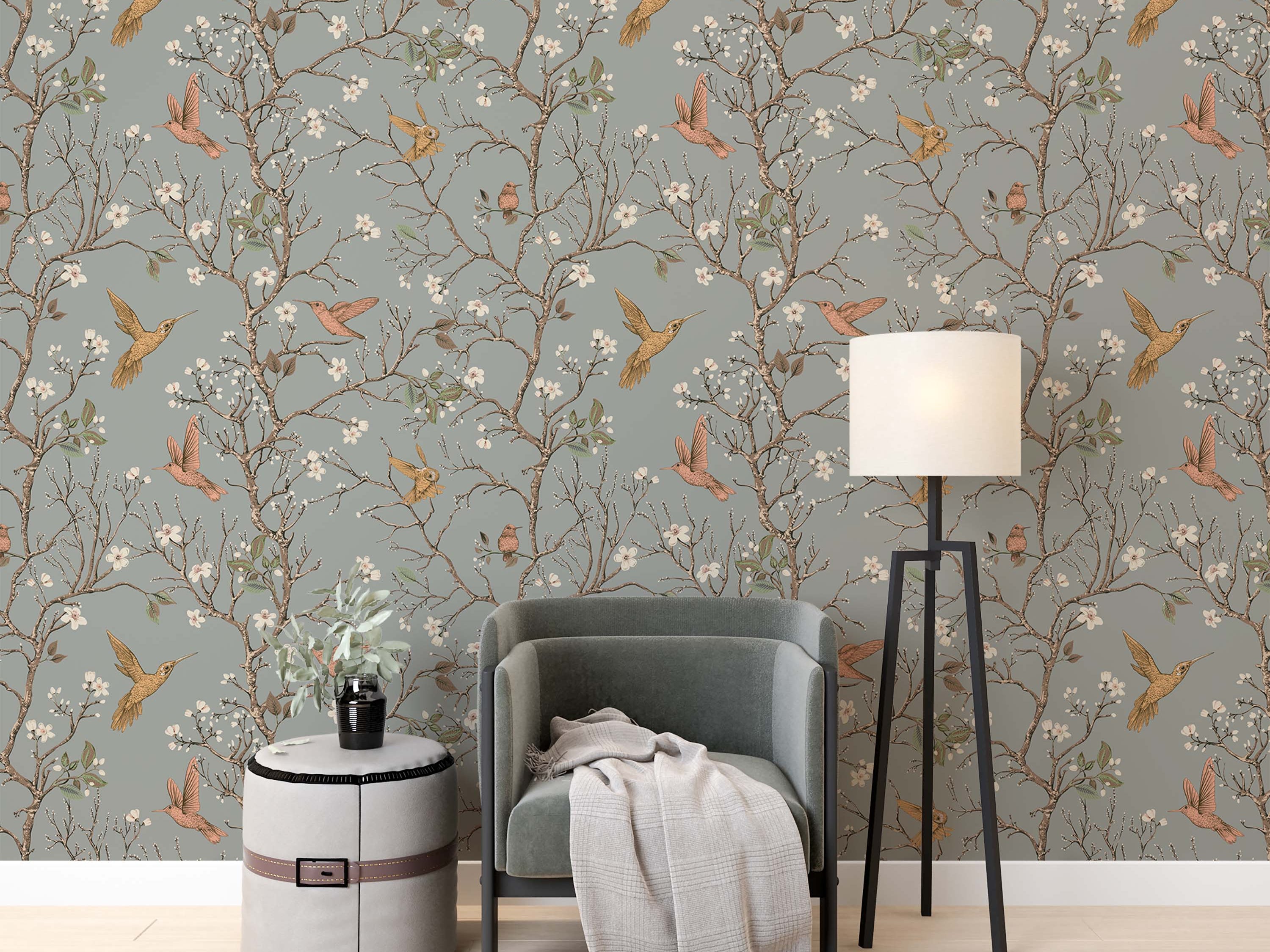 Illustrative wallpaper featuring golden and pink hummingbirds among flowering brown branches on a dusty blue-gray background.