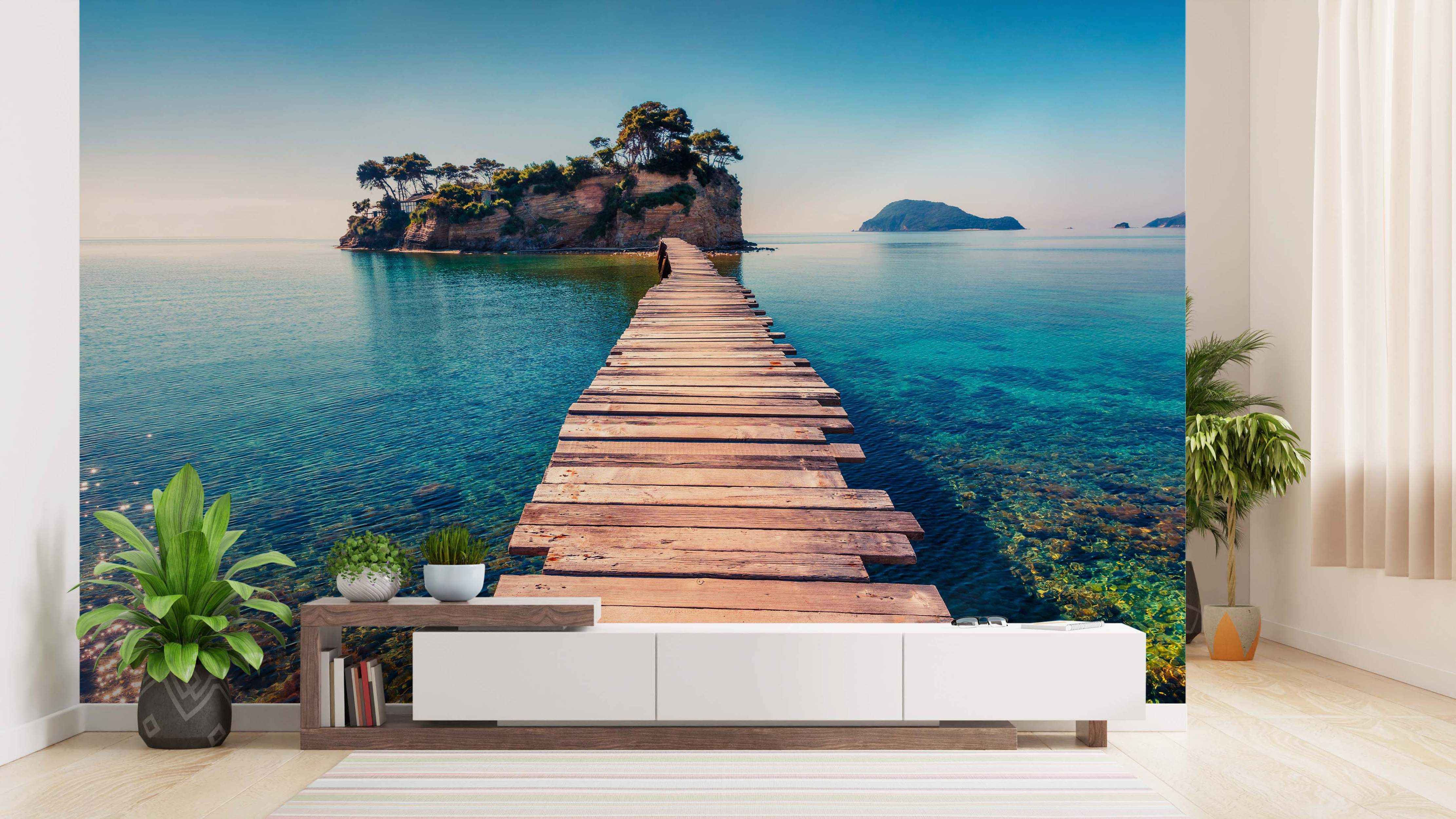 Mural featuring a wooden pier leading across clear turquoise water towards a small, tree-covered island under a blue sky.