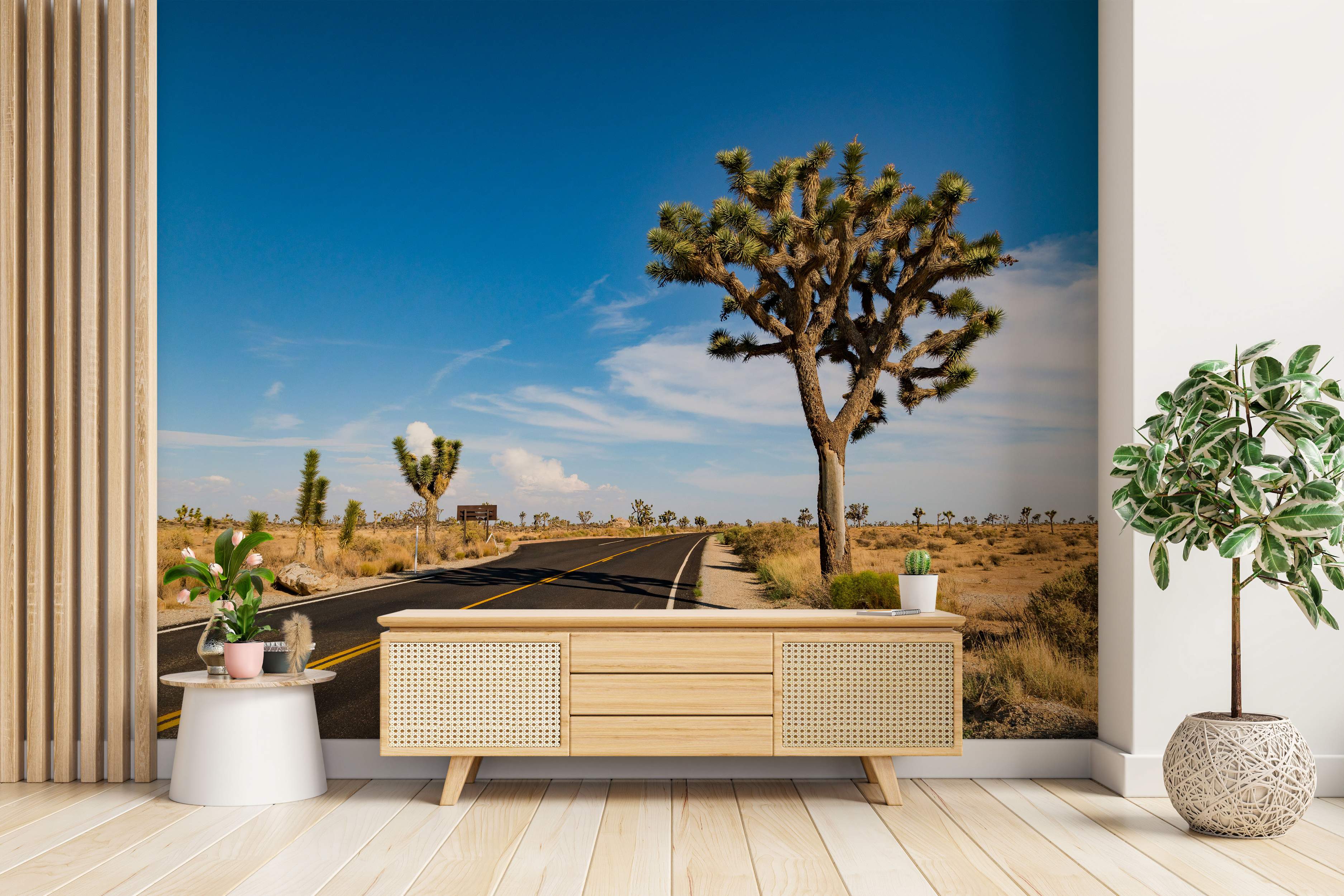 Mural depicting a prominent Joshua tree next to a winding desert road under a clear blue sky.