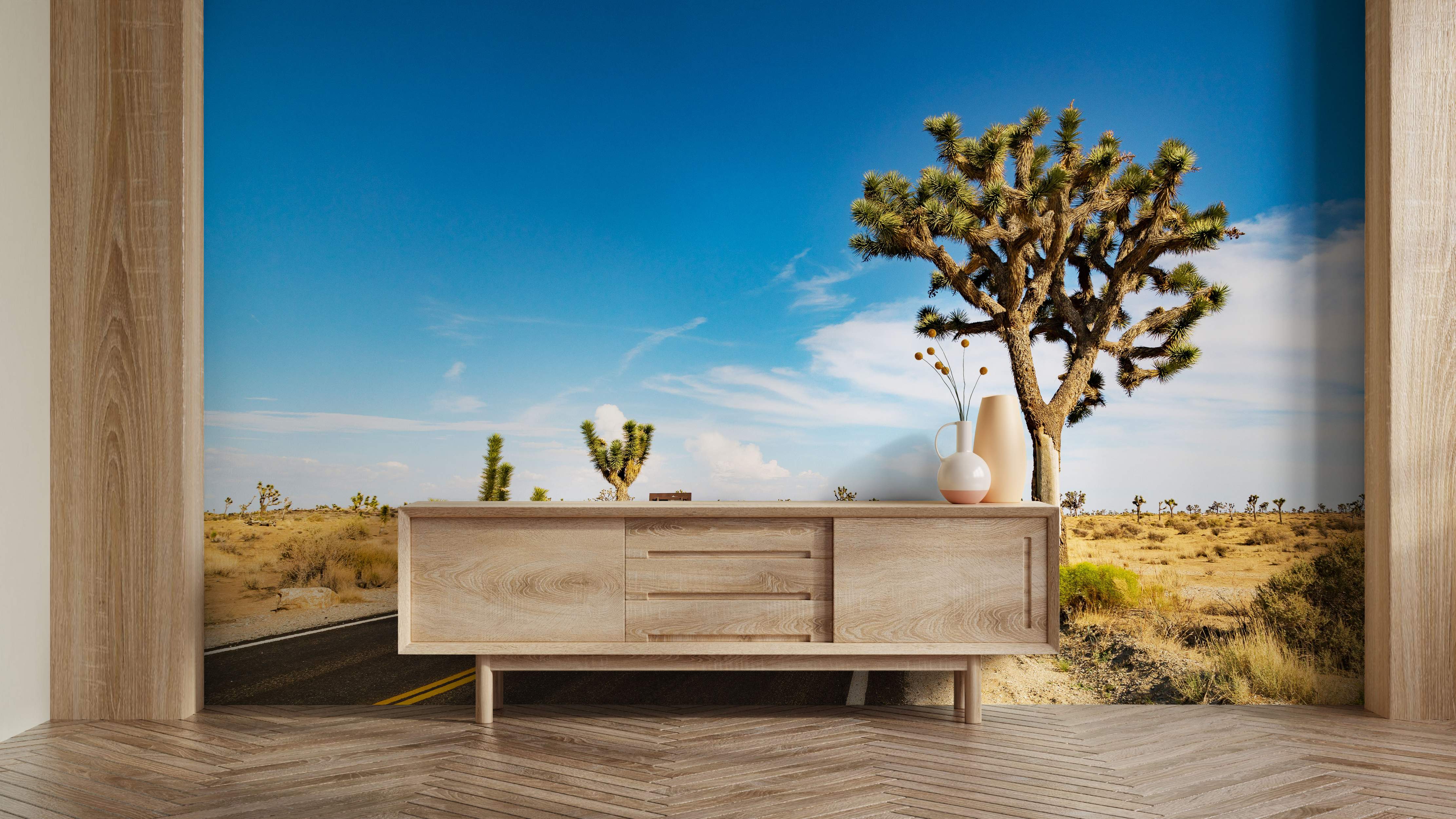 Photorealistic mural showing a desert highway stretching through arid land with Joshua trees under a bright blue sky.